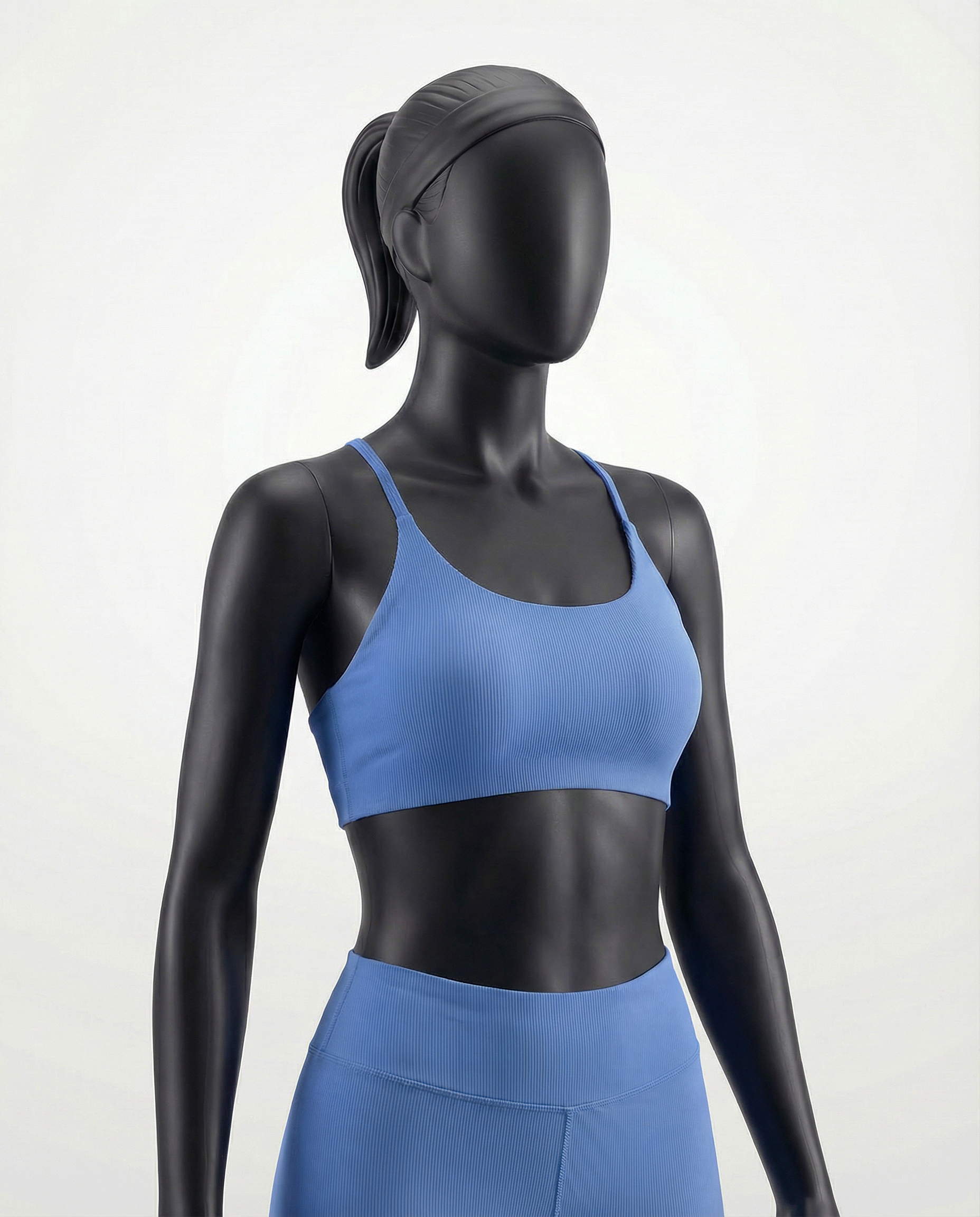 Mannequin wearing a blue sports bra and leggings on a white background