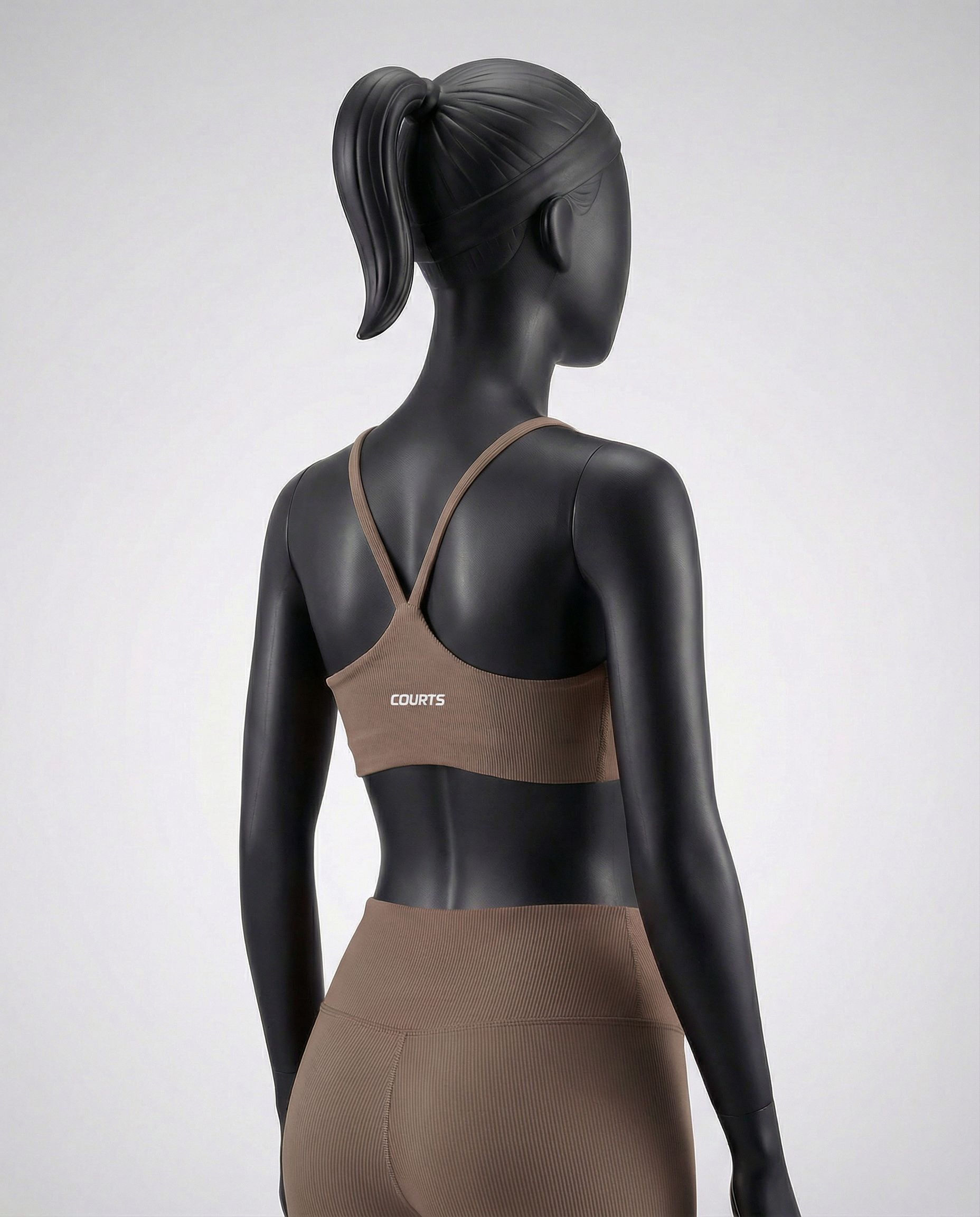 Mannequin wearing a brown sports bra and leggings on a white background
