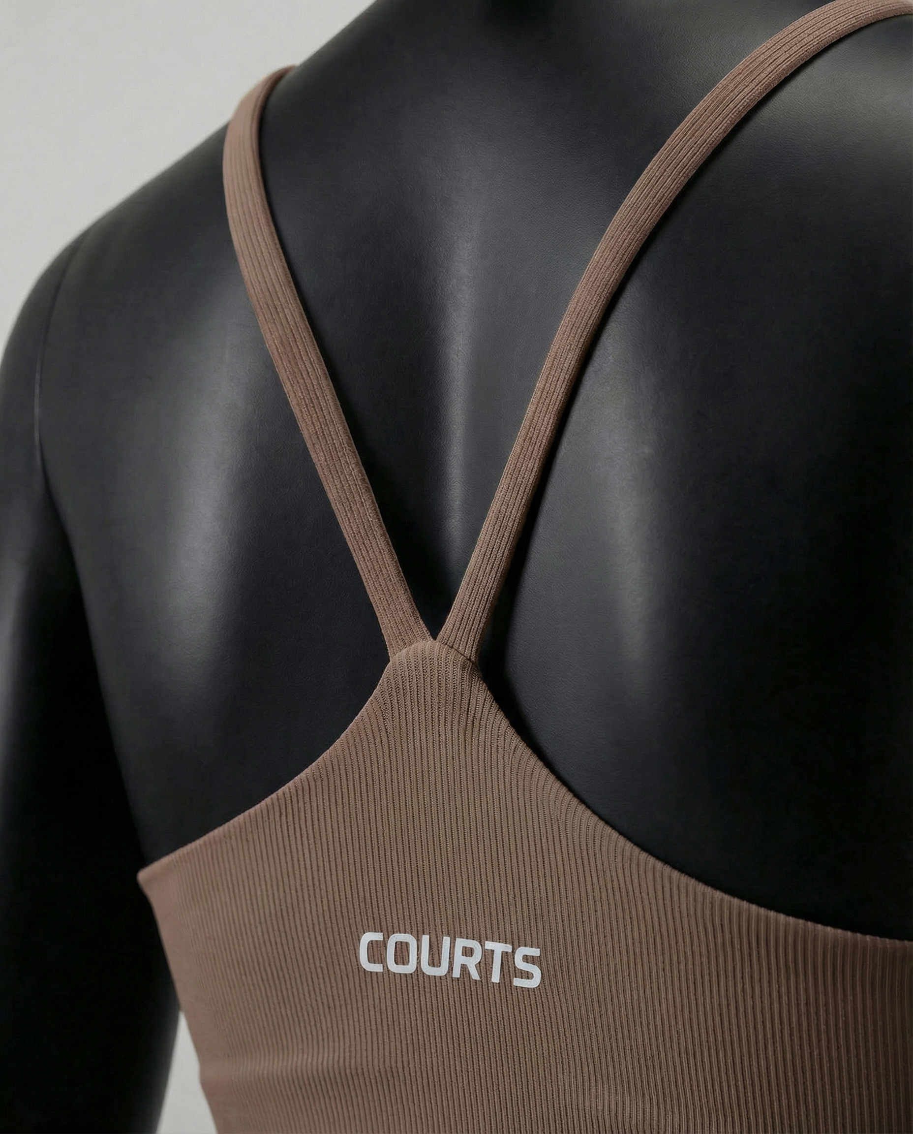 Mannequin wearing a brown sports bra and leggings on a white background