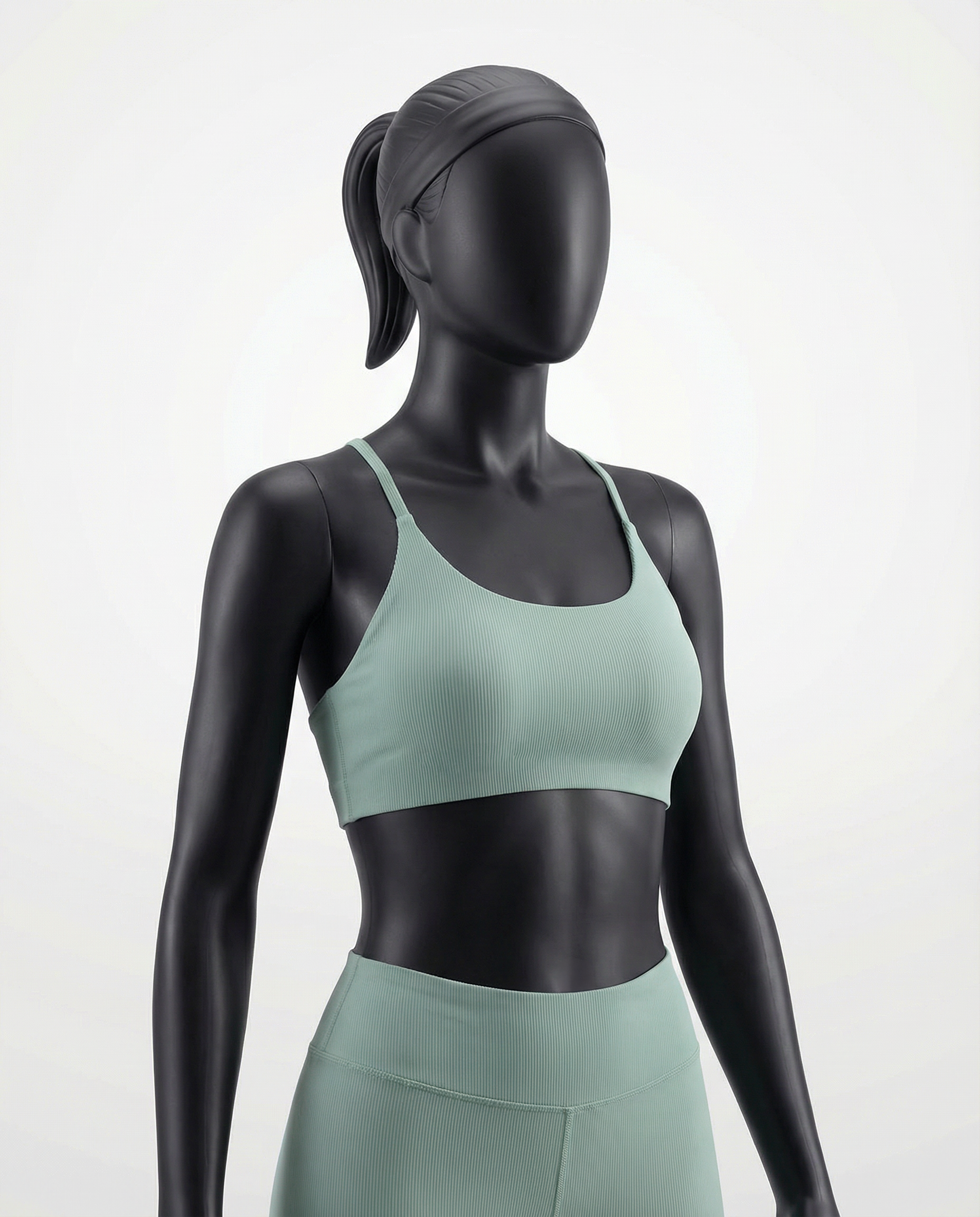 Mannequin wearing a green sports bra and leggings set on a light gray background