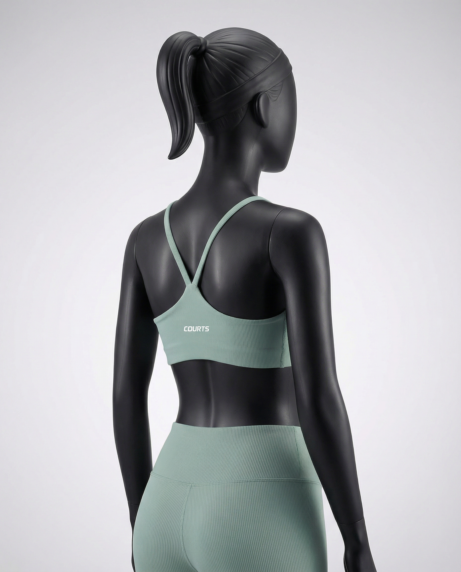 Mannequin wearing a green sports bra and leggings set on a light gray background
