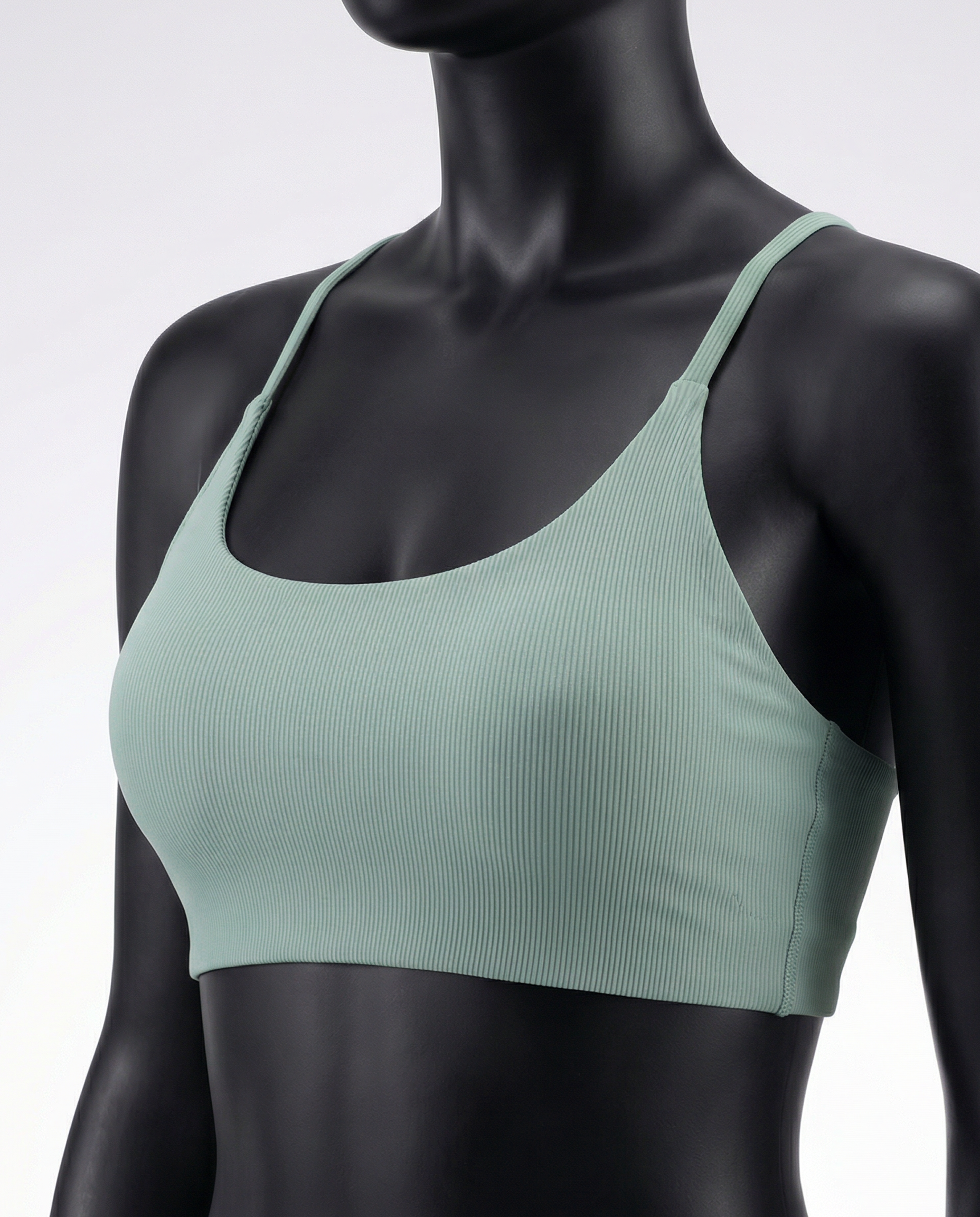 Mannequin wearing a green sports bra and leggings set on a light gray background