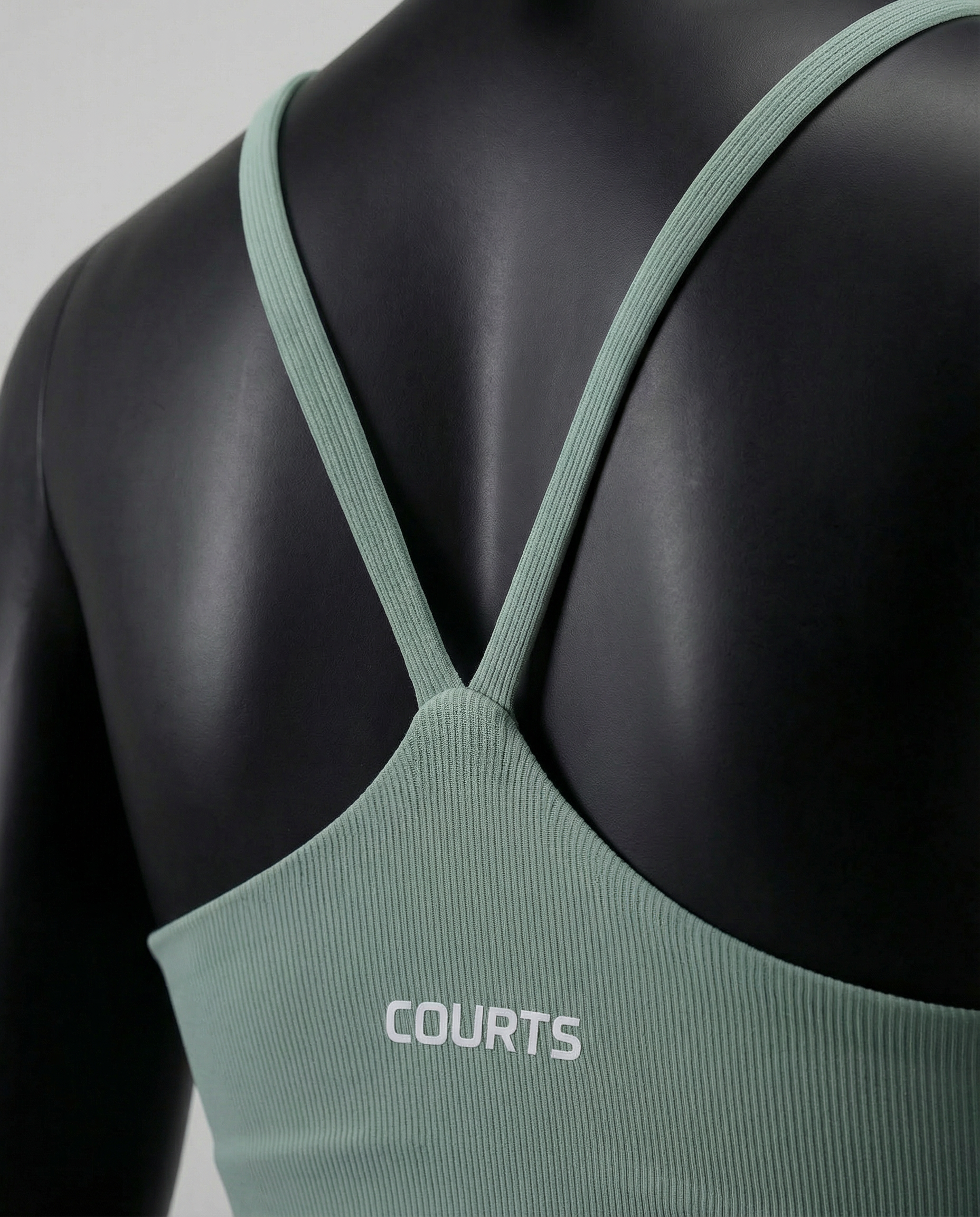 Mannequin wearing a green sports bra and leggings set on a light gray background