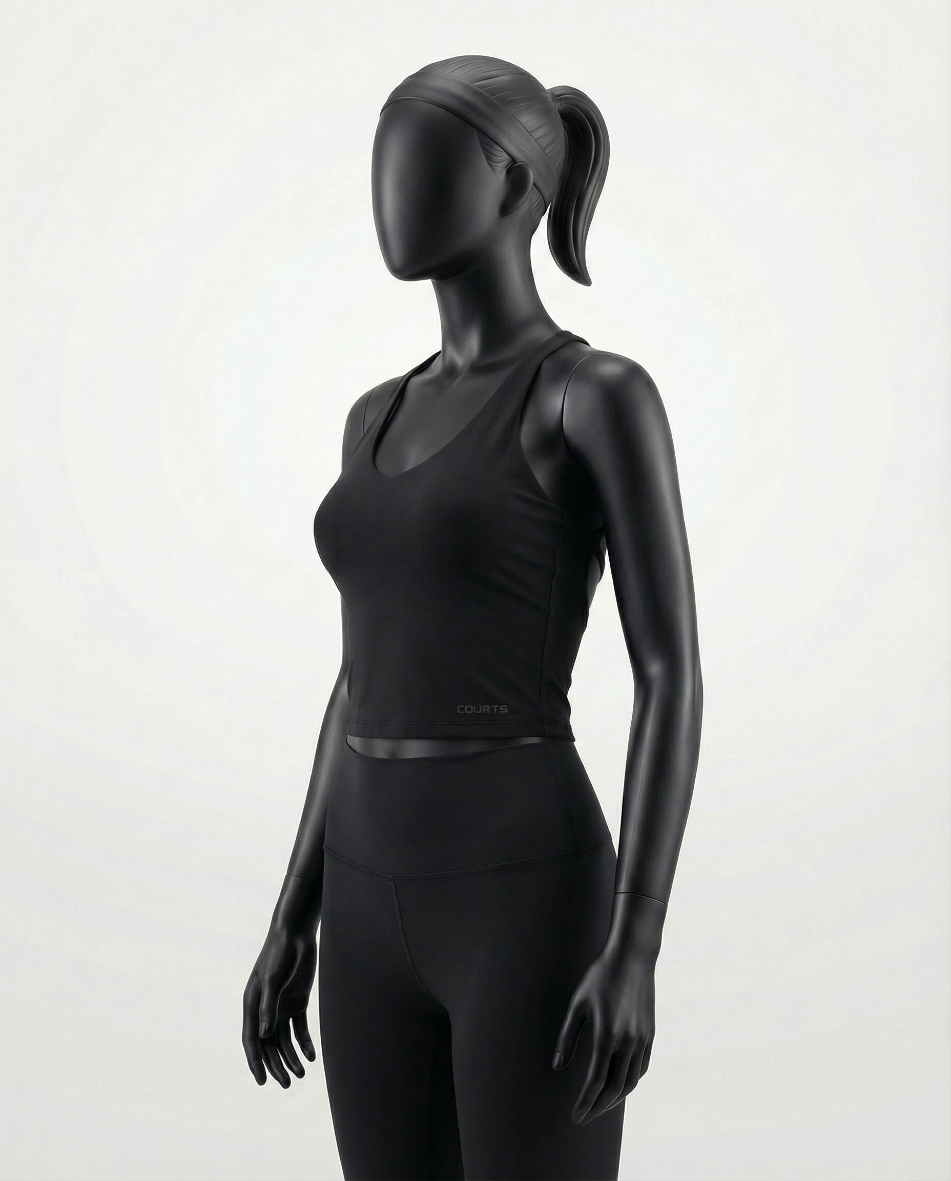 Courts black athletic crop top and leggings on a mannequin against a white background