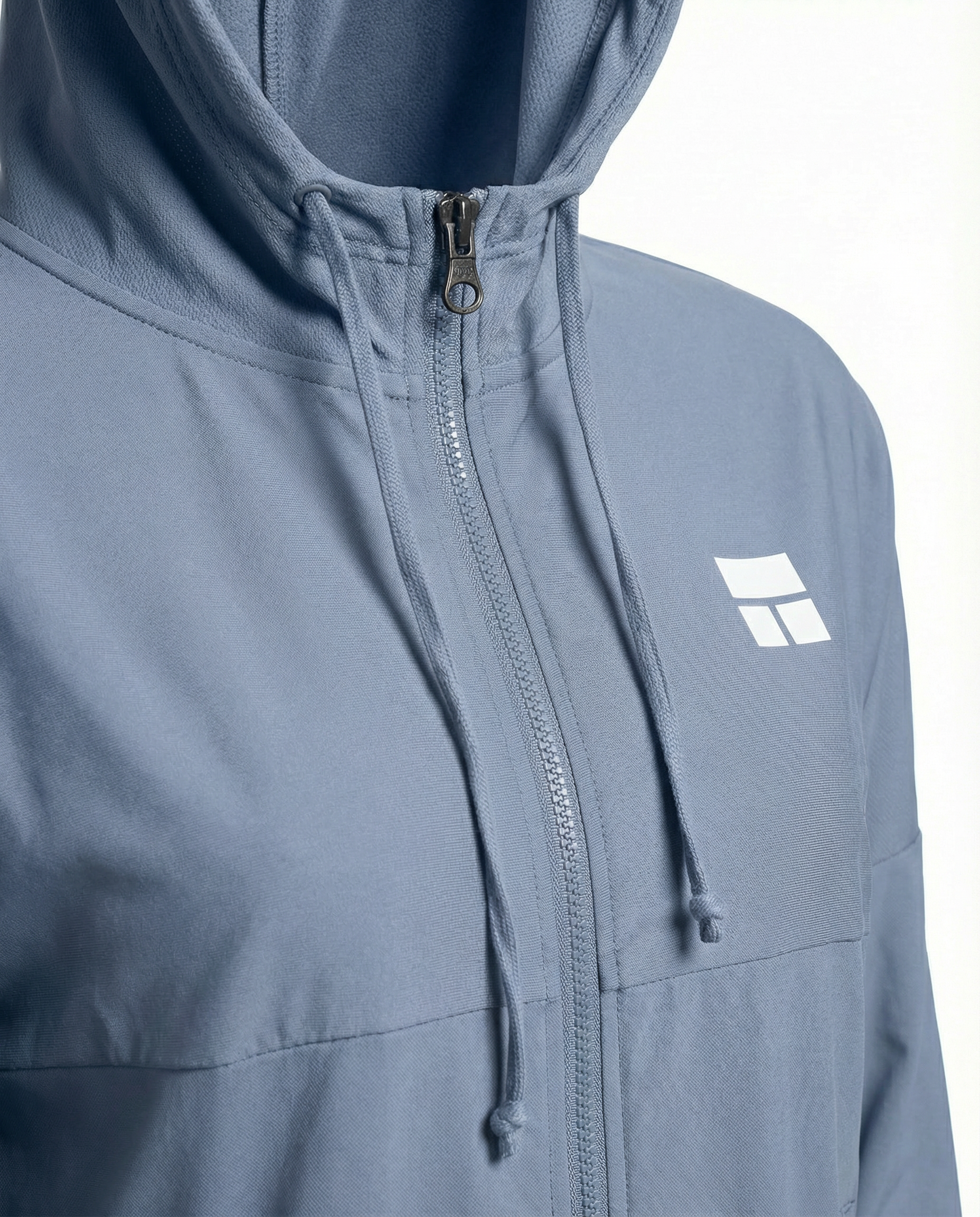 Woman wearing a light blue jacket with a logo on a white background