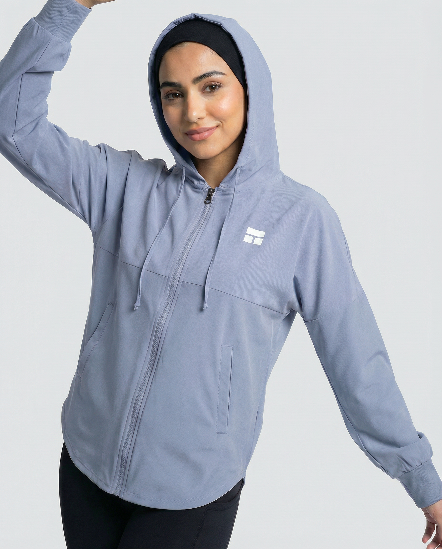 Woman wearing a light blue jacket with a logo on a white background