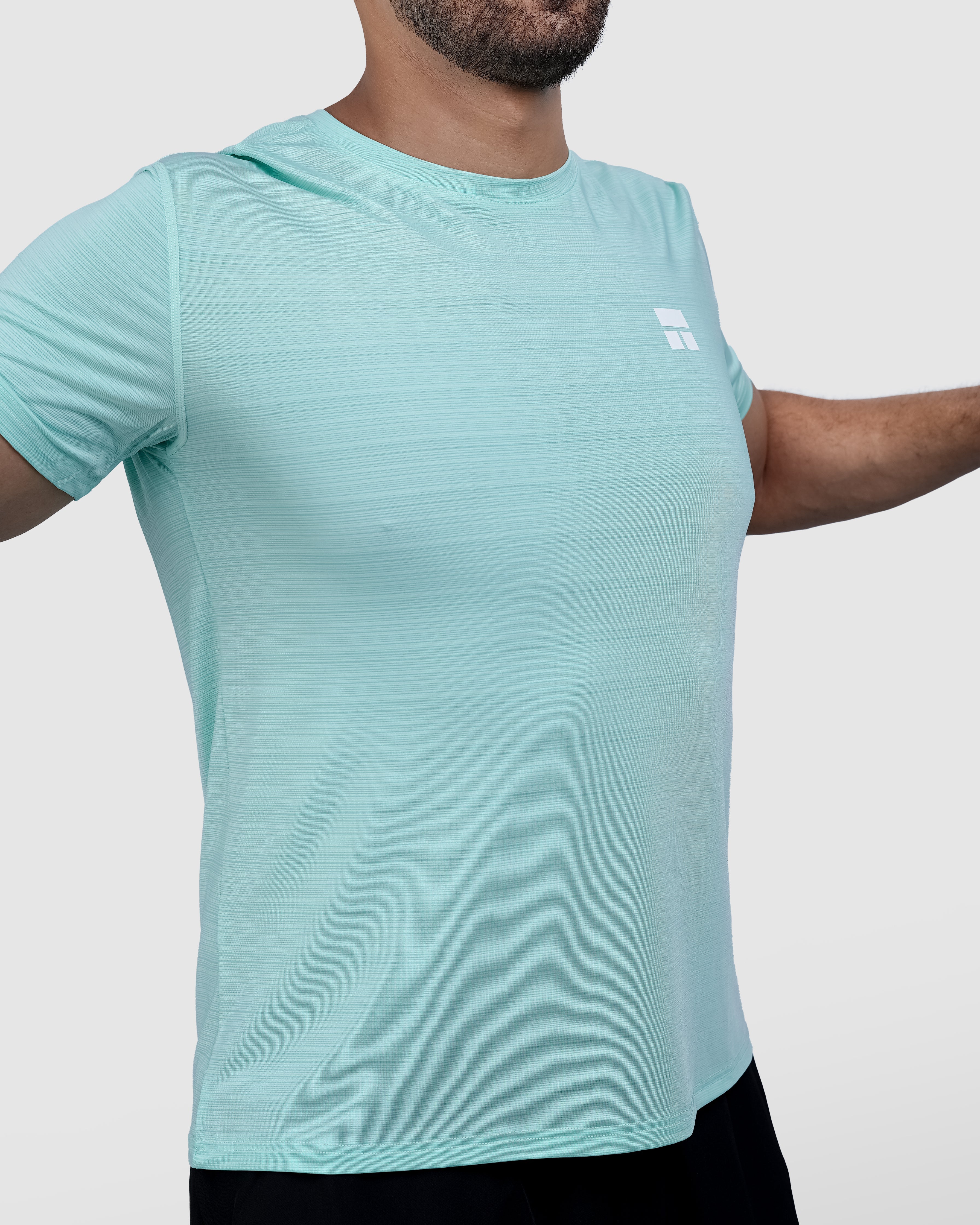 Man wearing a light blue t-shirt and black shorts on a white background