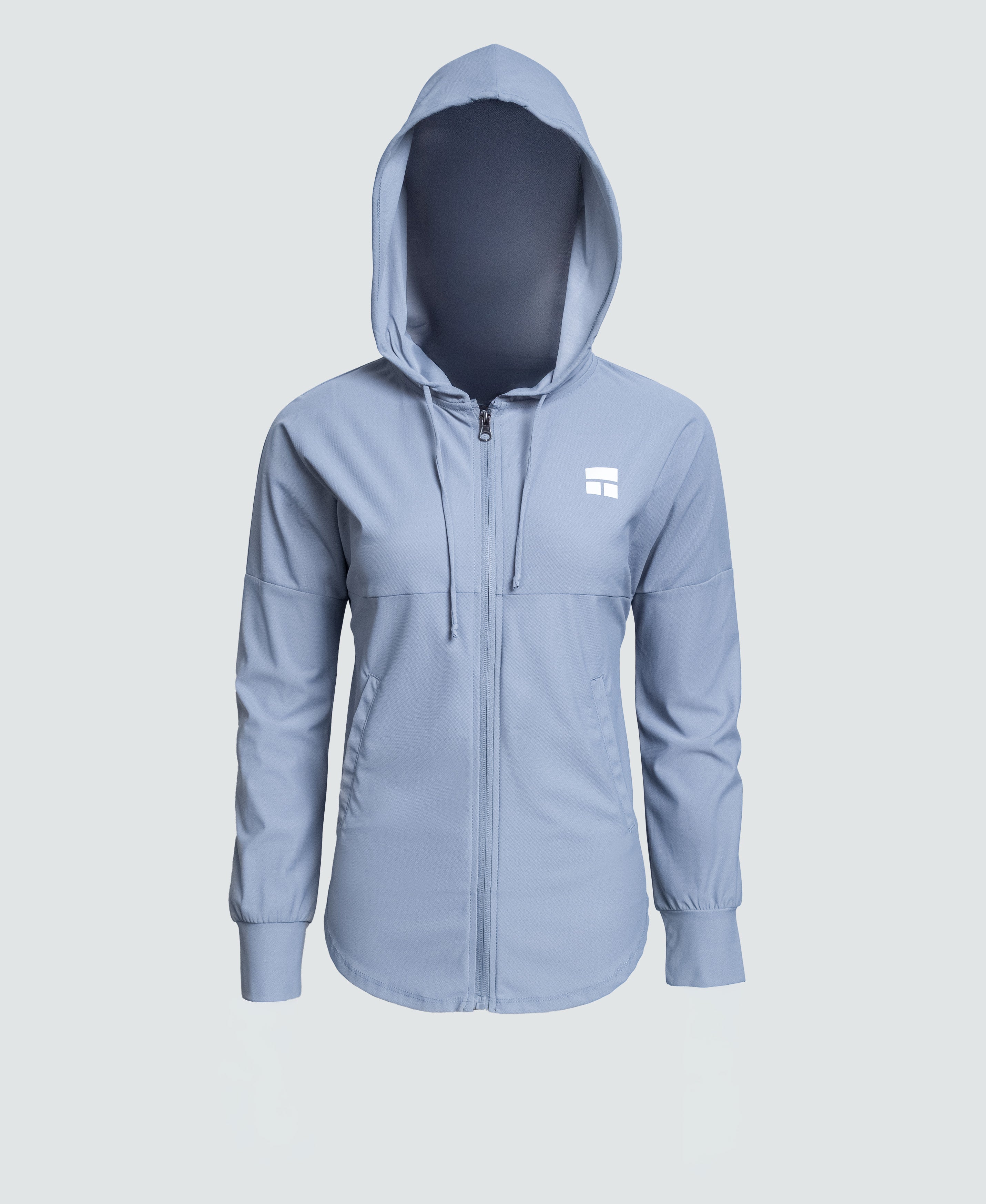 Woman wearing a light blue jacket with a logo on a white background