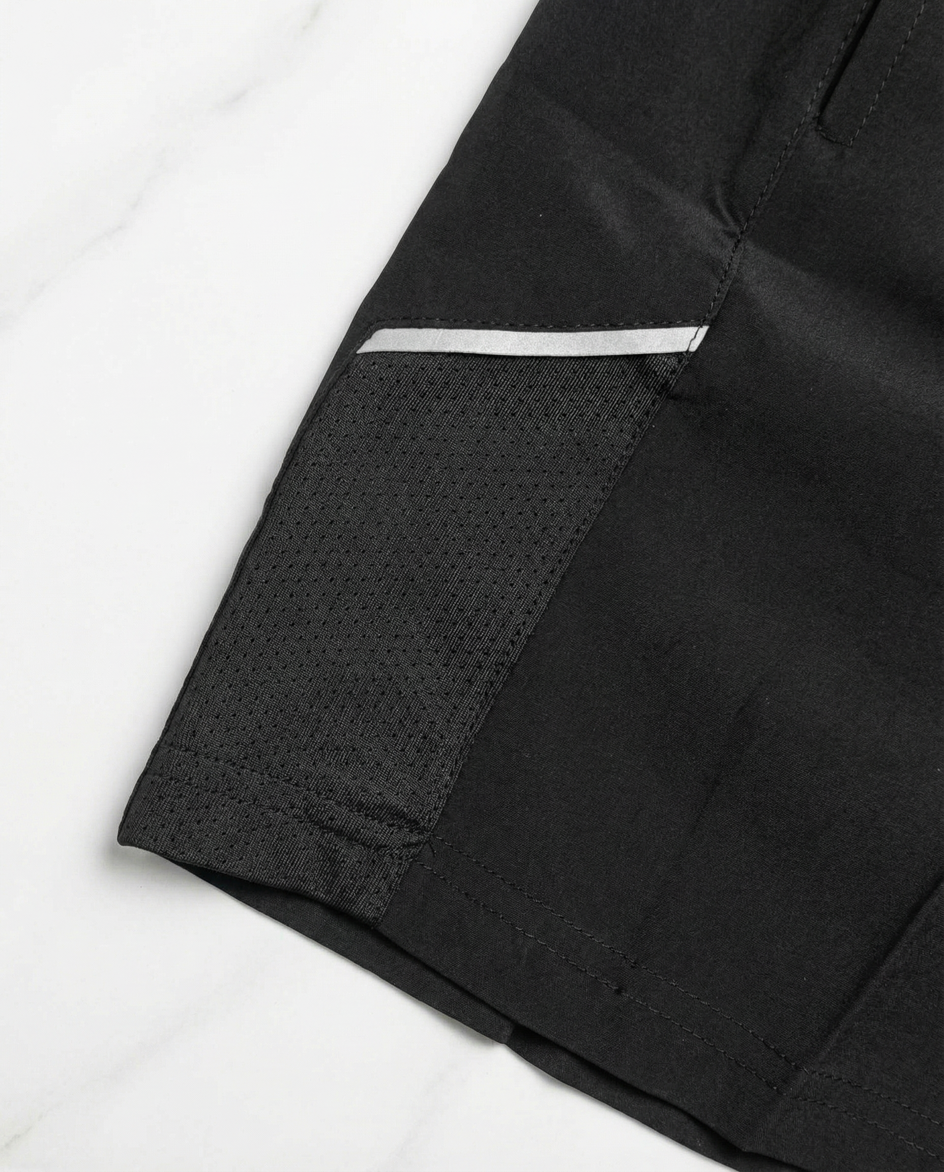 Child wearing a Courts sport white t-shirt and black shorts on a white background