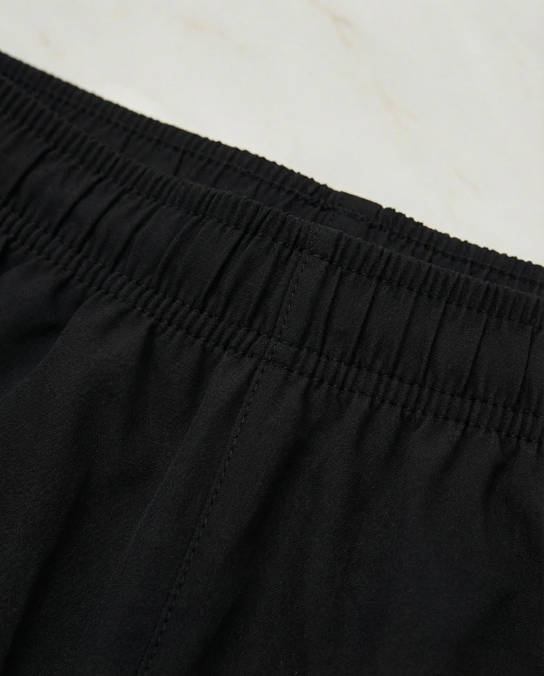 Child wearing a Courts sport white t-shirt and black shorts on a white background