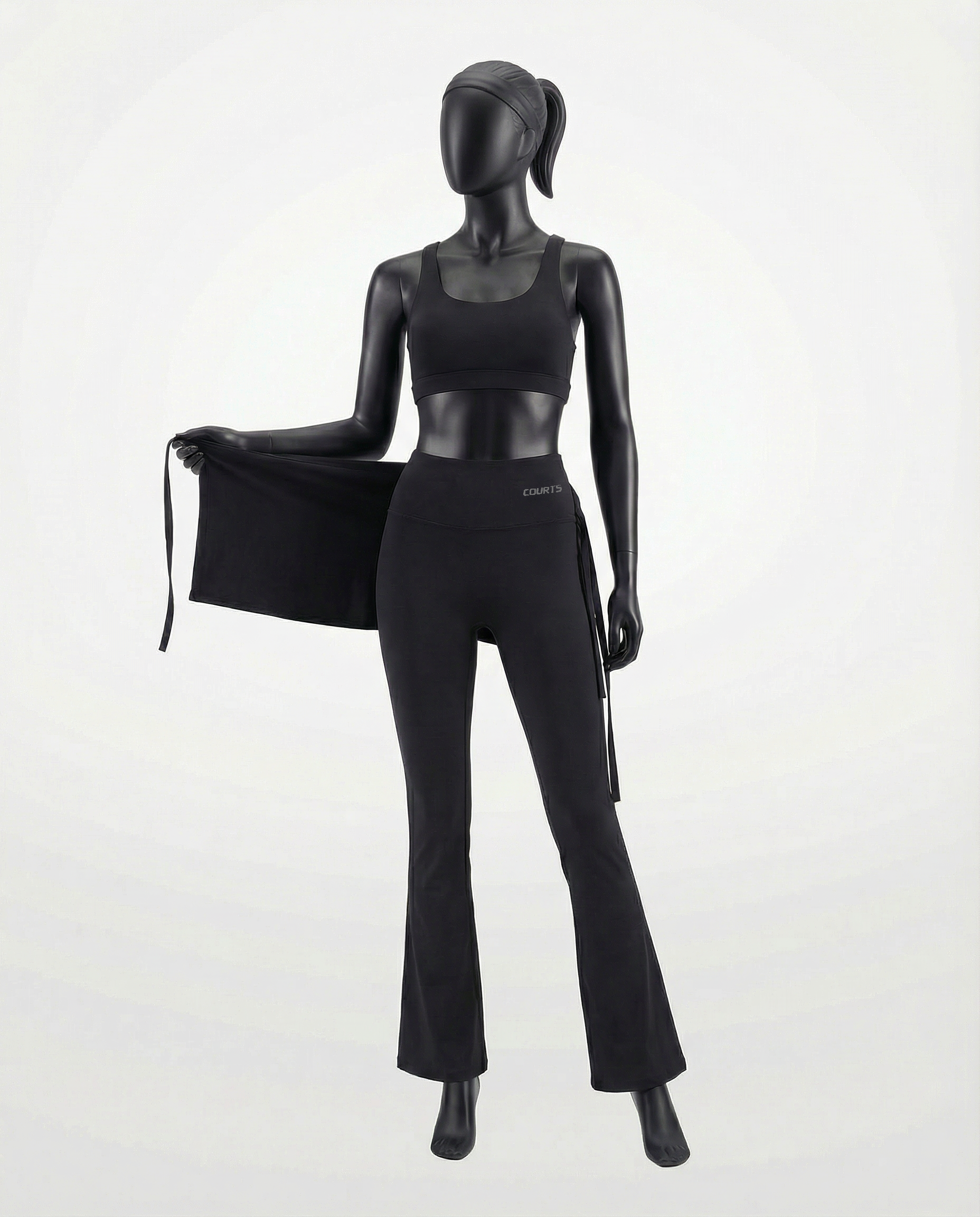 Mannequin wearing a black skirt and pants with 'Courts' branding on a white background