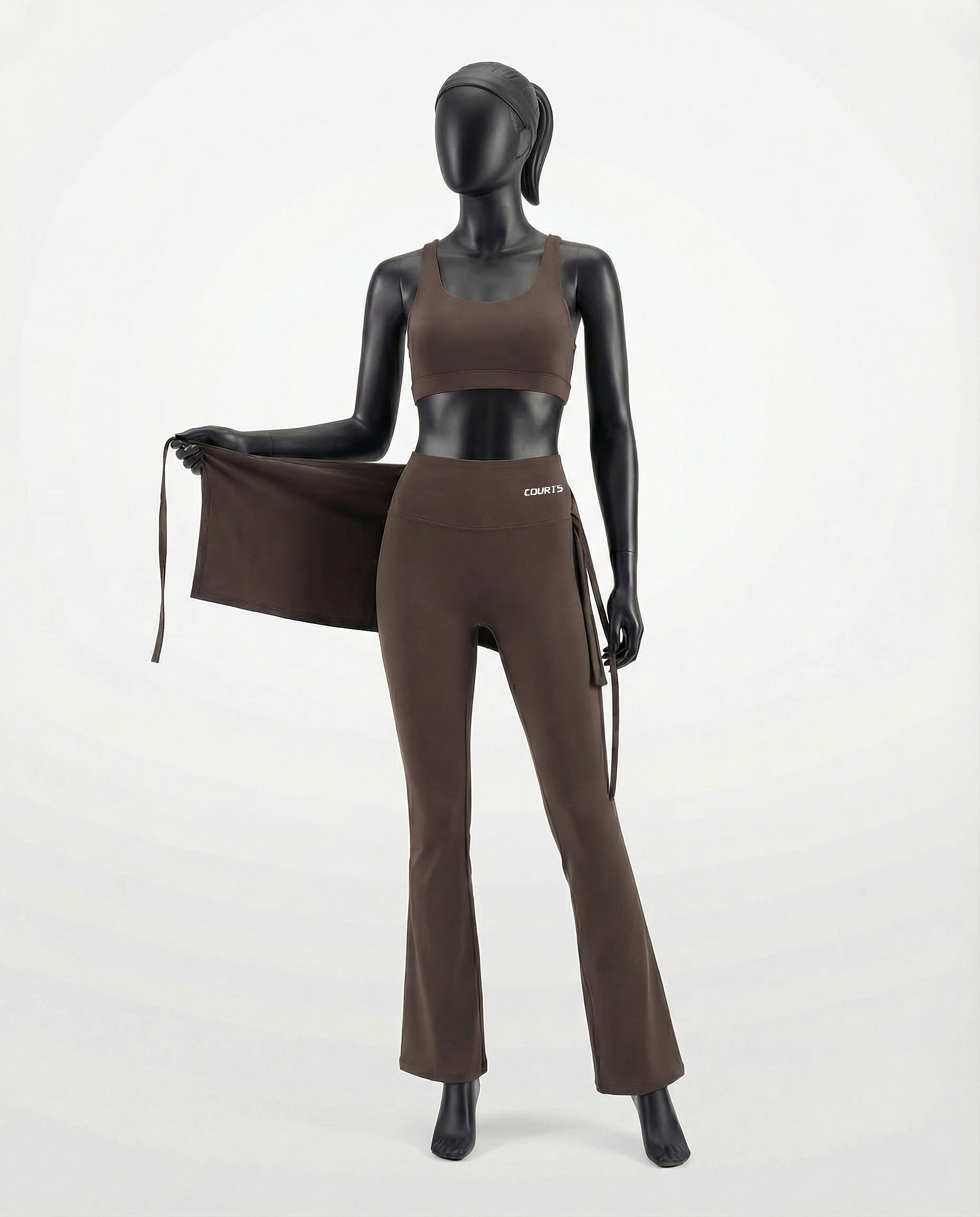Mannequin wearing a brown skirt and pants with 'Courts' branding on a white background