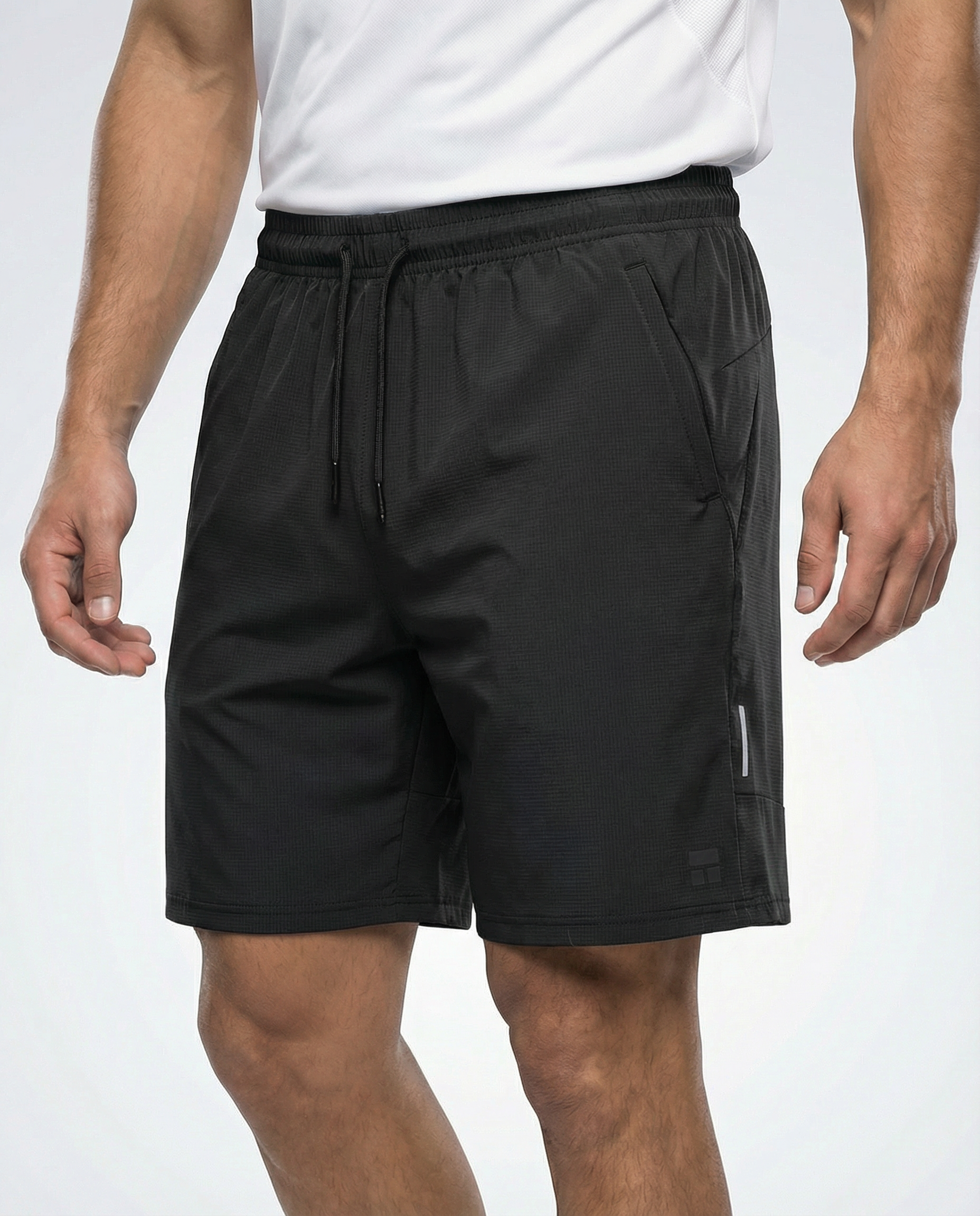 Person wearing courts sport black shorts with a white background