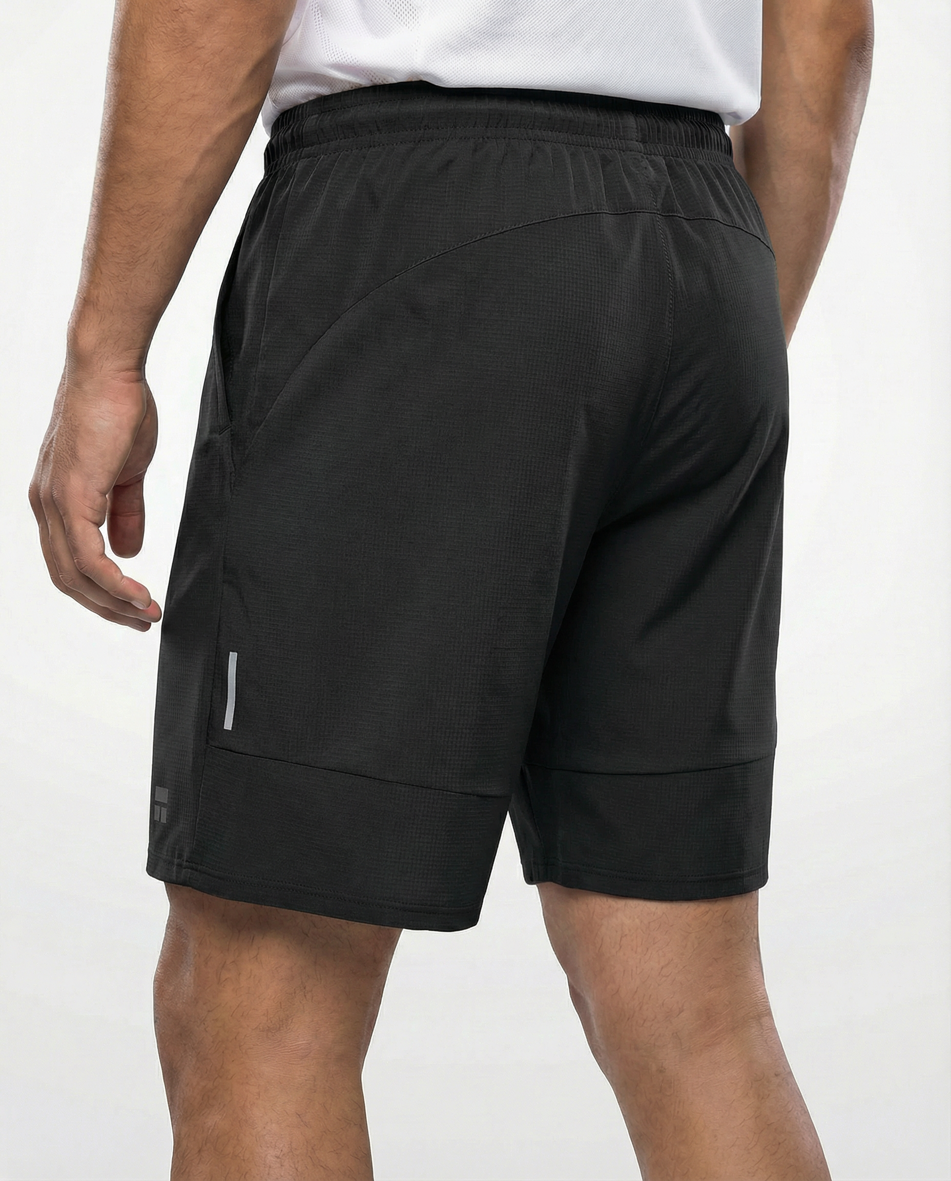 Person wearing courts sport black shorts with a white background