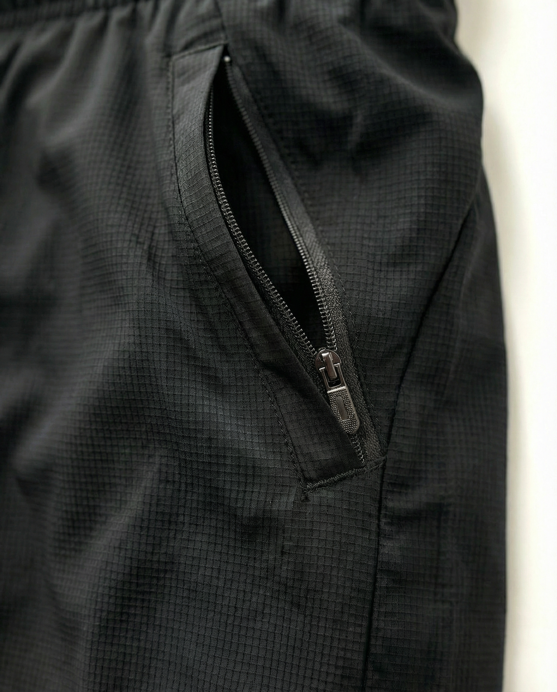 Person wearing courts sport black shorts with a white background