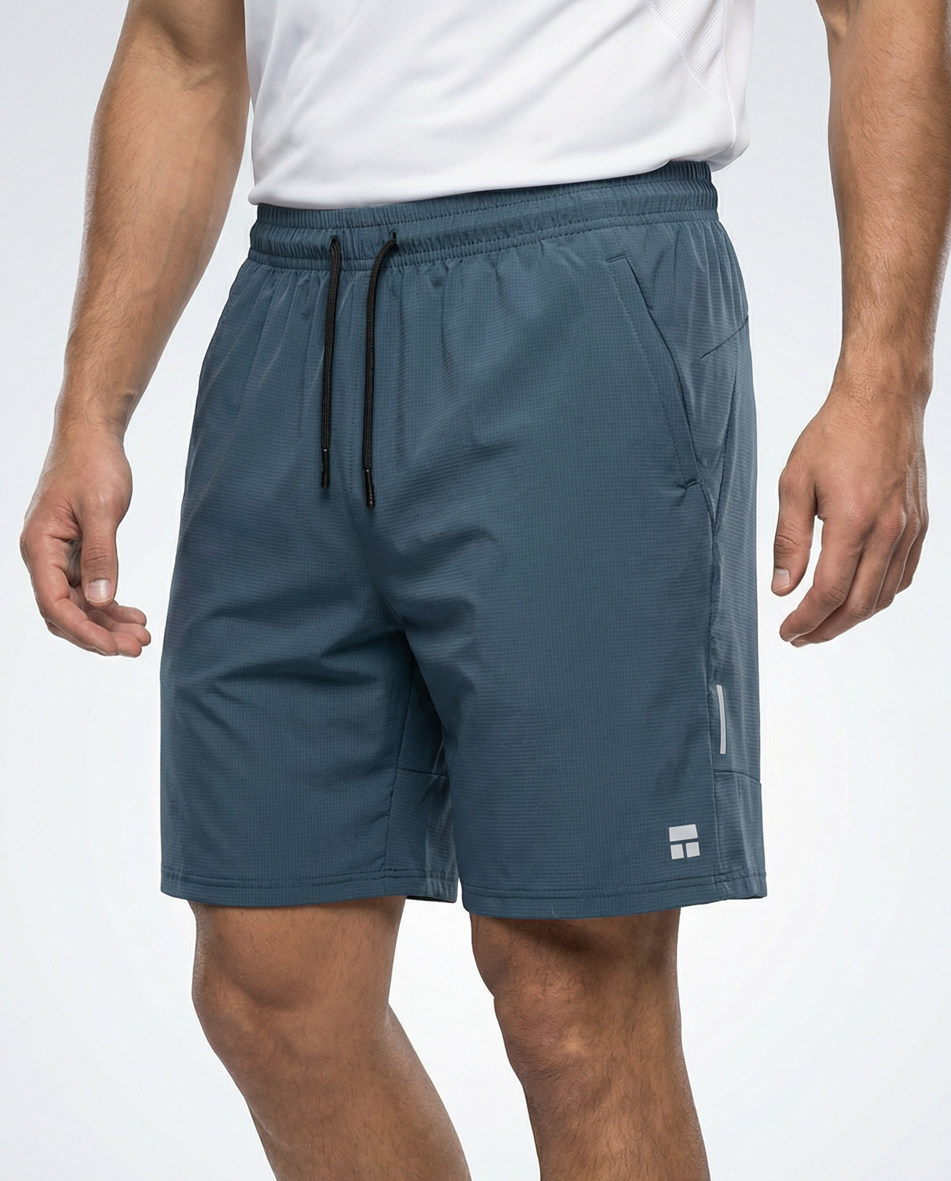 Person wearing haze blue athletic shorts with a visible Courts brand logo on a white background