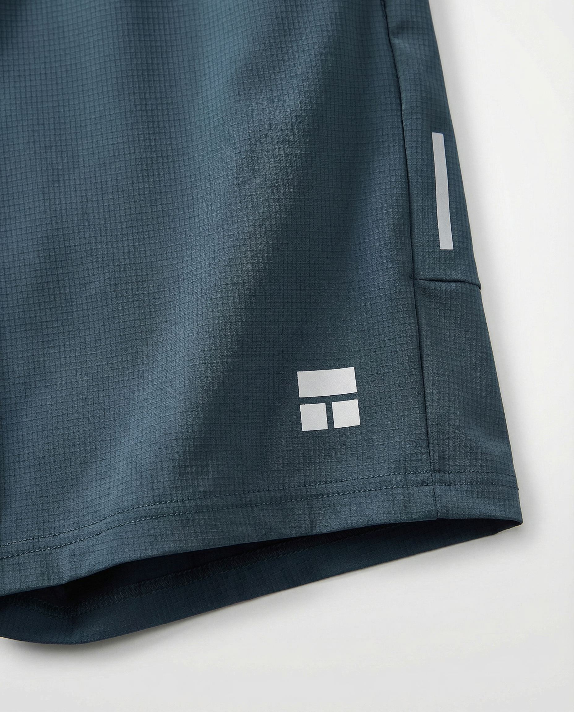 Person wearing haze blue athletic shorts with a visible Courts brand logo on a white background