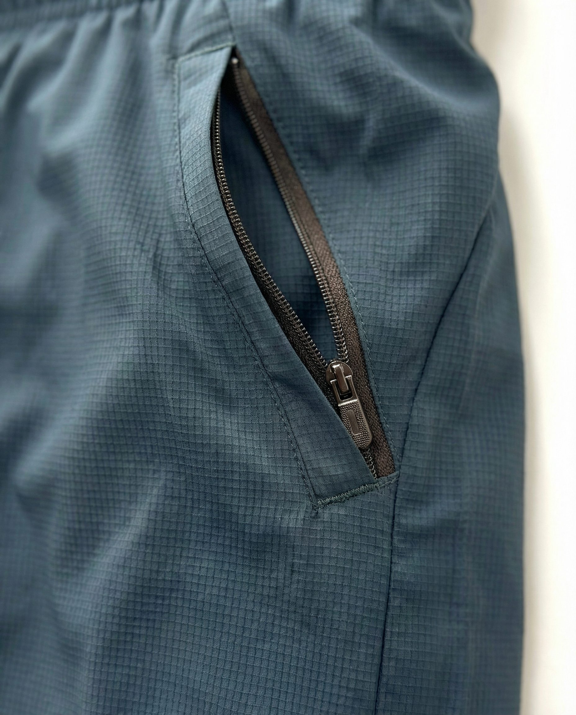 Person wearing haze blue athletic shorts with a visible Courts brand logo on a white background