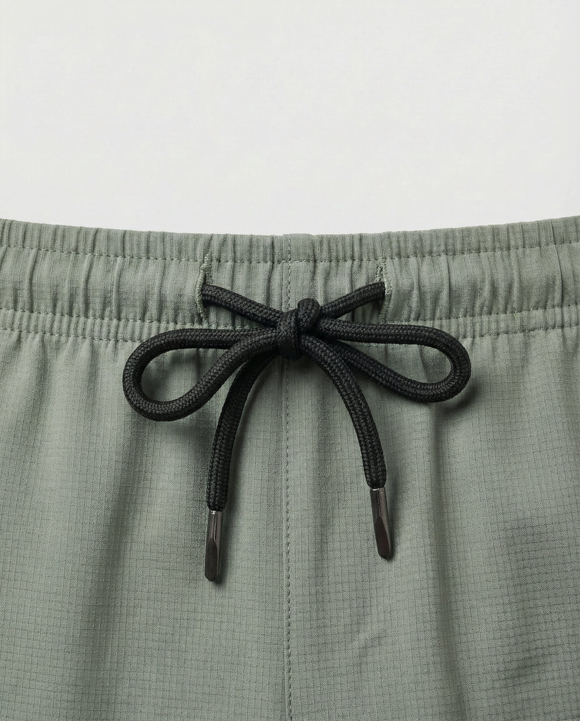 Person wearing Courts sport army green shorts with a white background