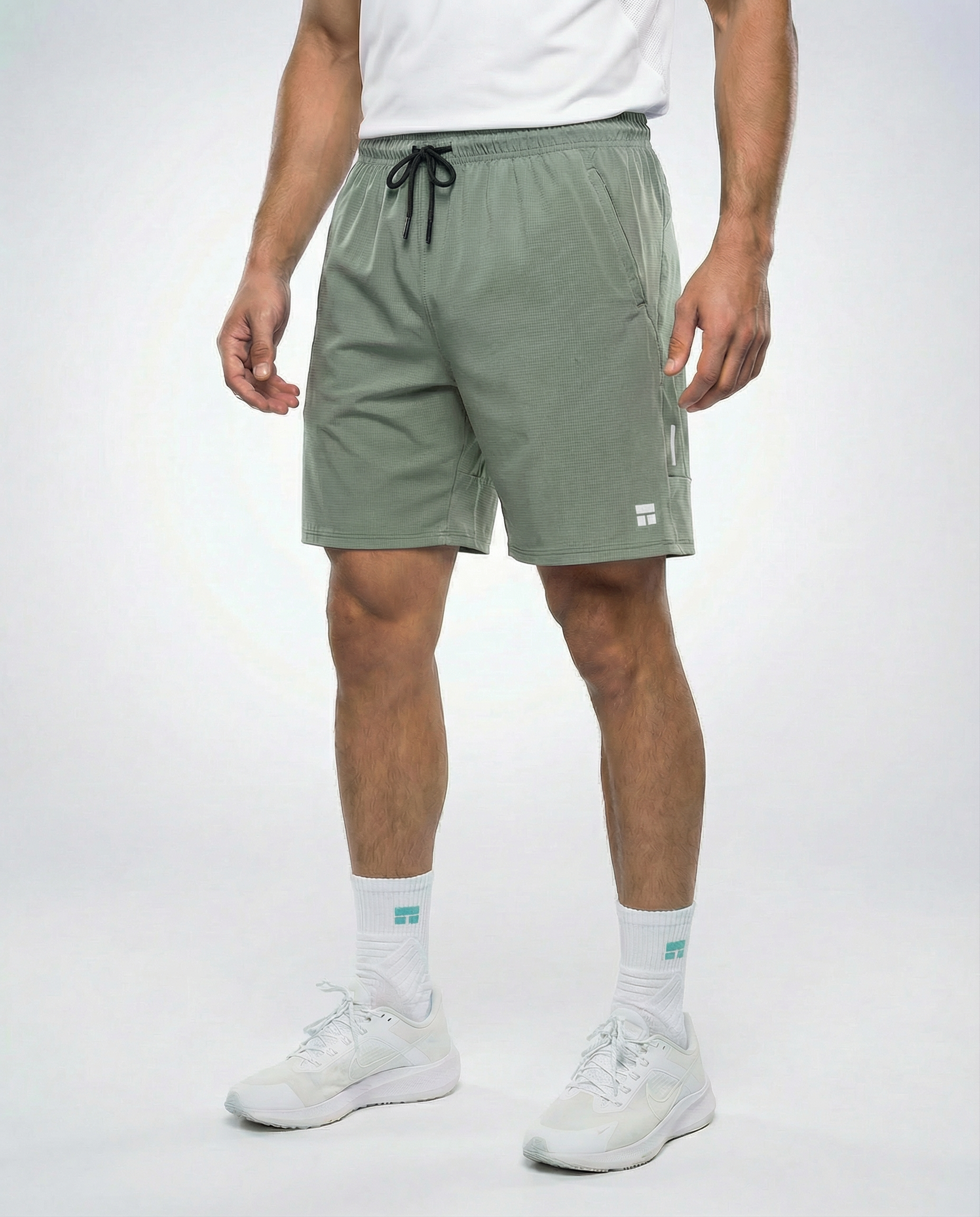 Person wearing Courts sport army green shorts with a white background
