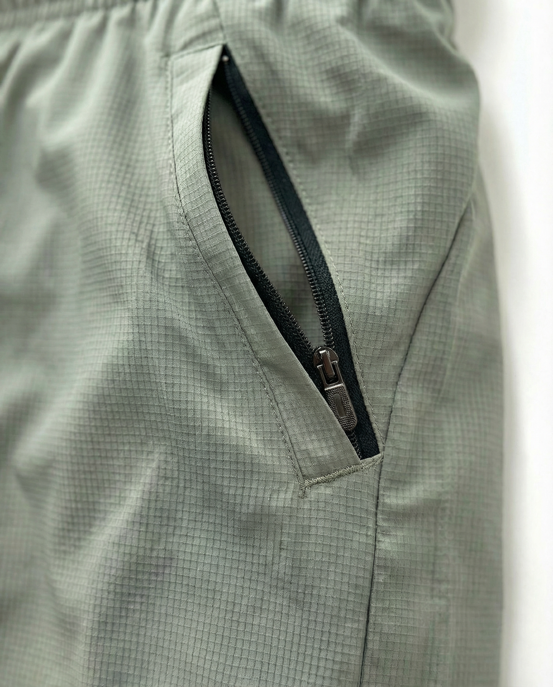 Person wearing Courts sport army green shorts with a white background