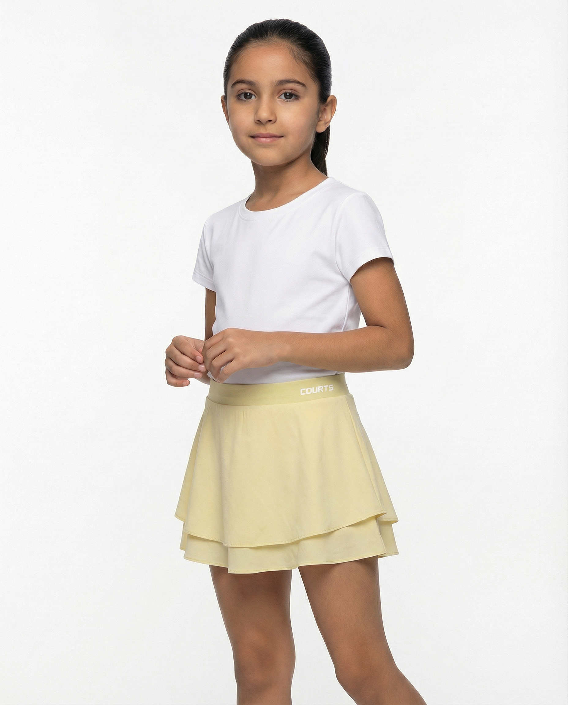 Young girl wearing a white t-shirt and yellow skirt skort short on a white background
Courts Sport