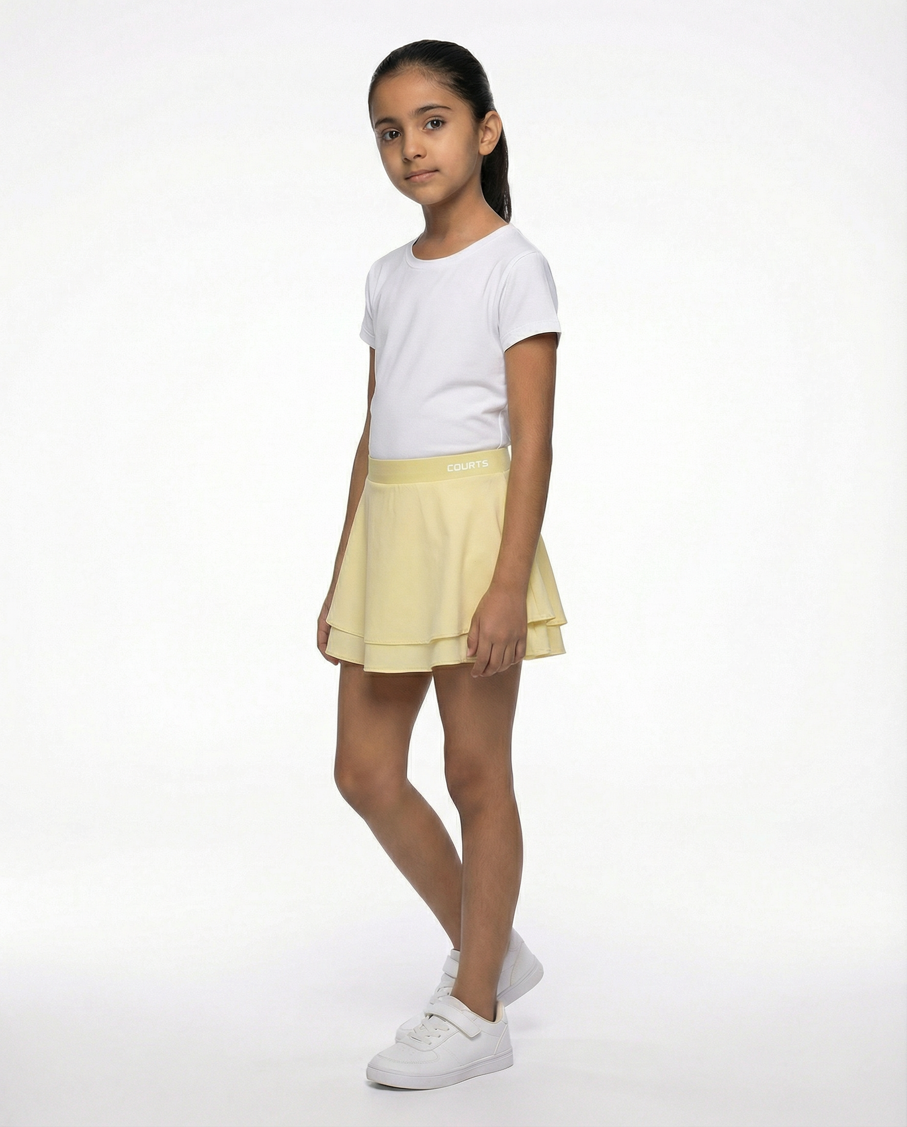 Young girl wearing a white t-shirt and yellow skirt skort short on a white background
Courts Sport