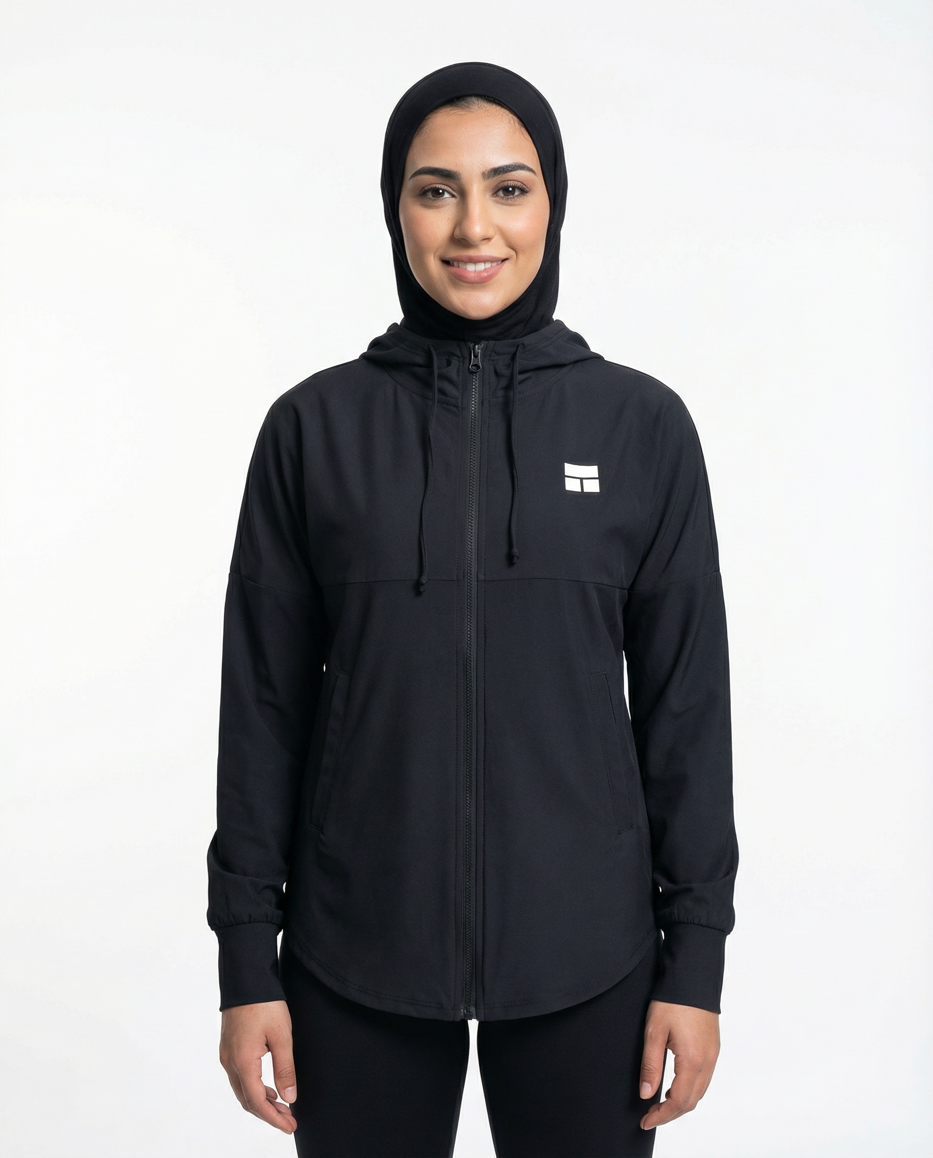 Person wearing a black hooded jacket with a logo on a white background