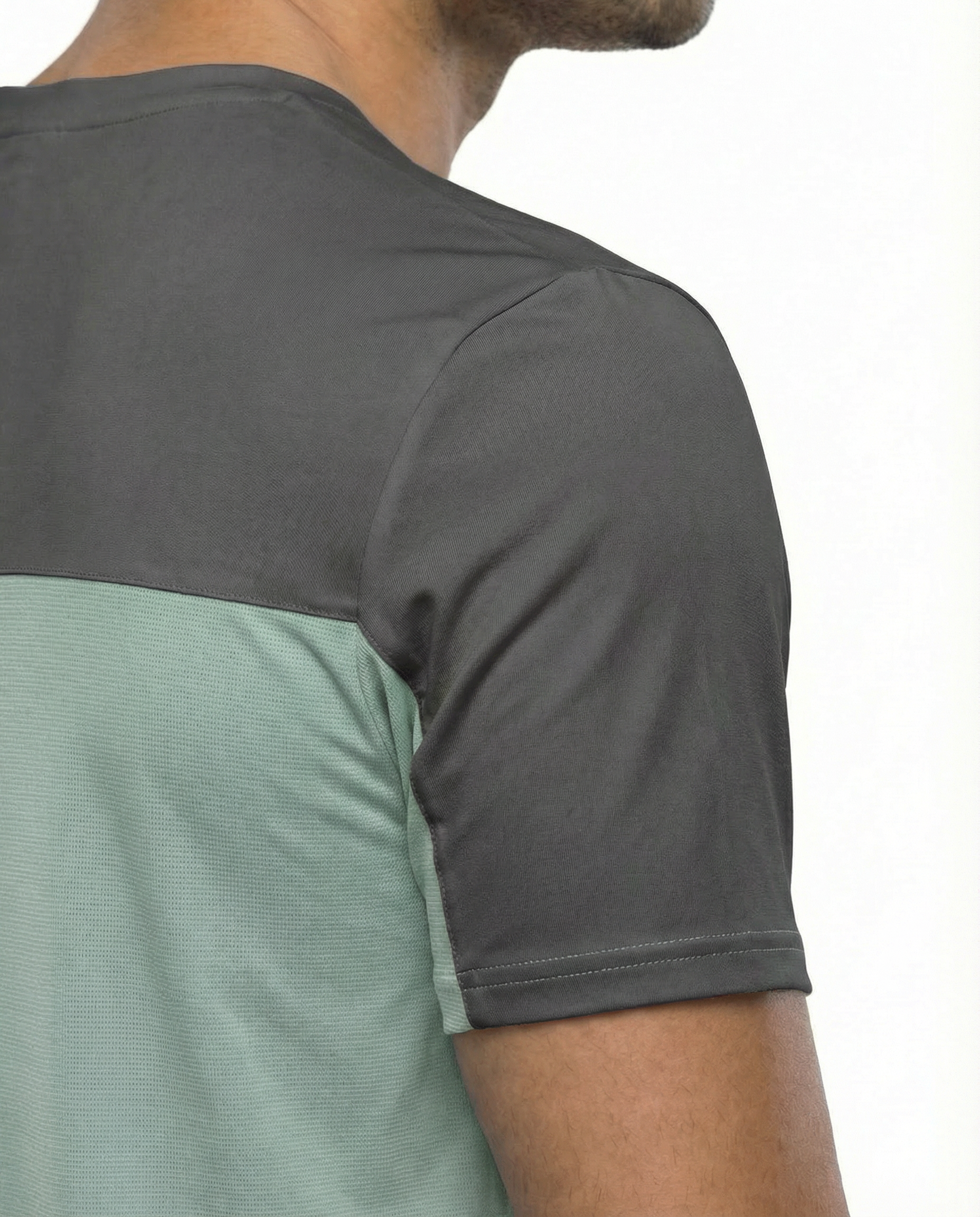 Man wearing a green athletic shirt with a logo on a white background
Courts Sport