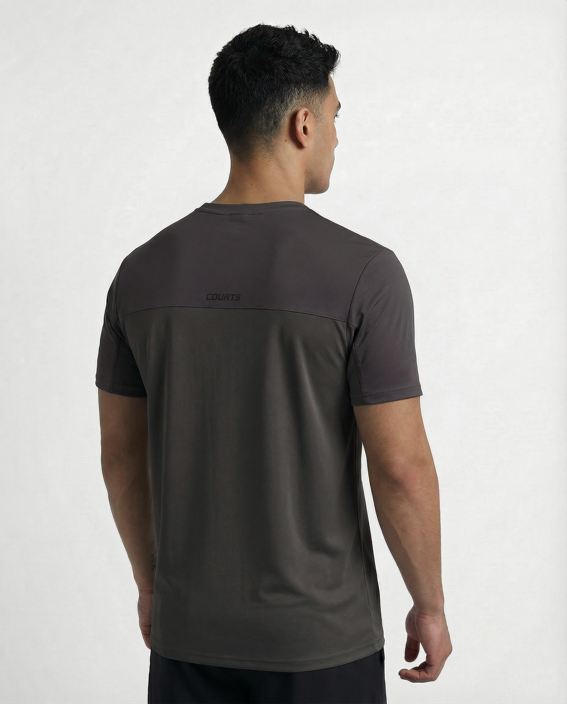 Man wearing a dark gray athletic shirt with black sleeves on a white background
Courts Sport