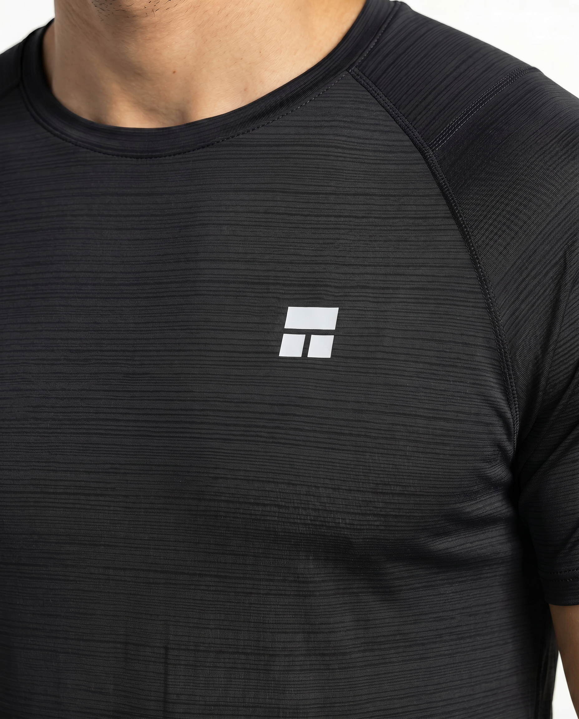 Man wearing a black athletic outfit with a logo on a white background