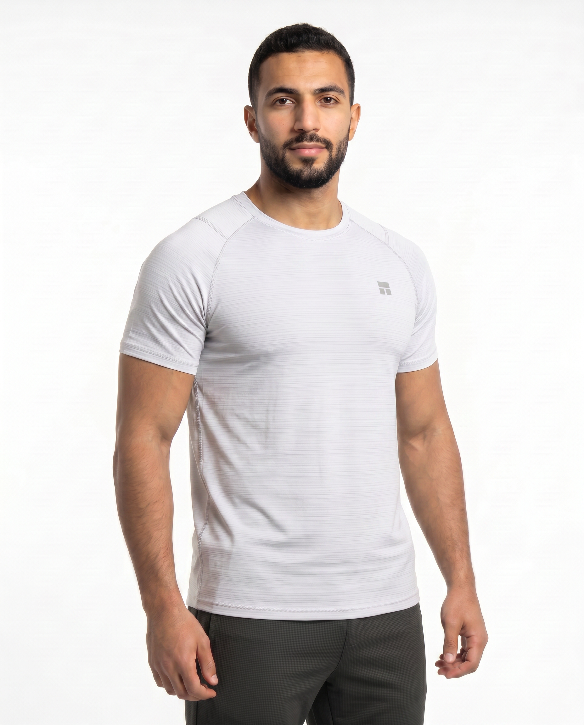 Man wearing a white t-shirt with a small logo on a white background