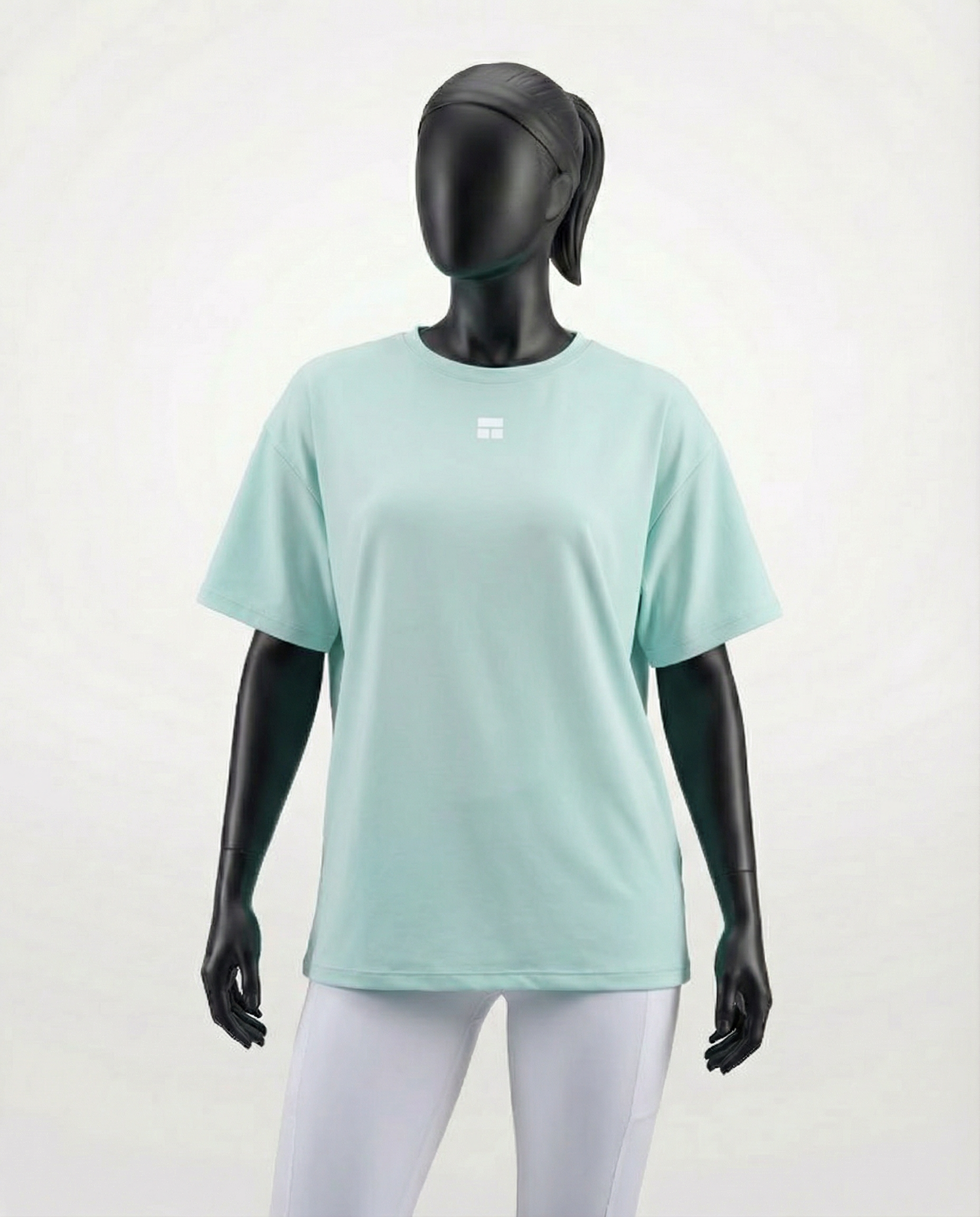 Mannequin wearing an oversized light green t-shirt on a plain background
