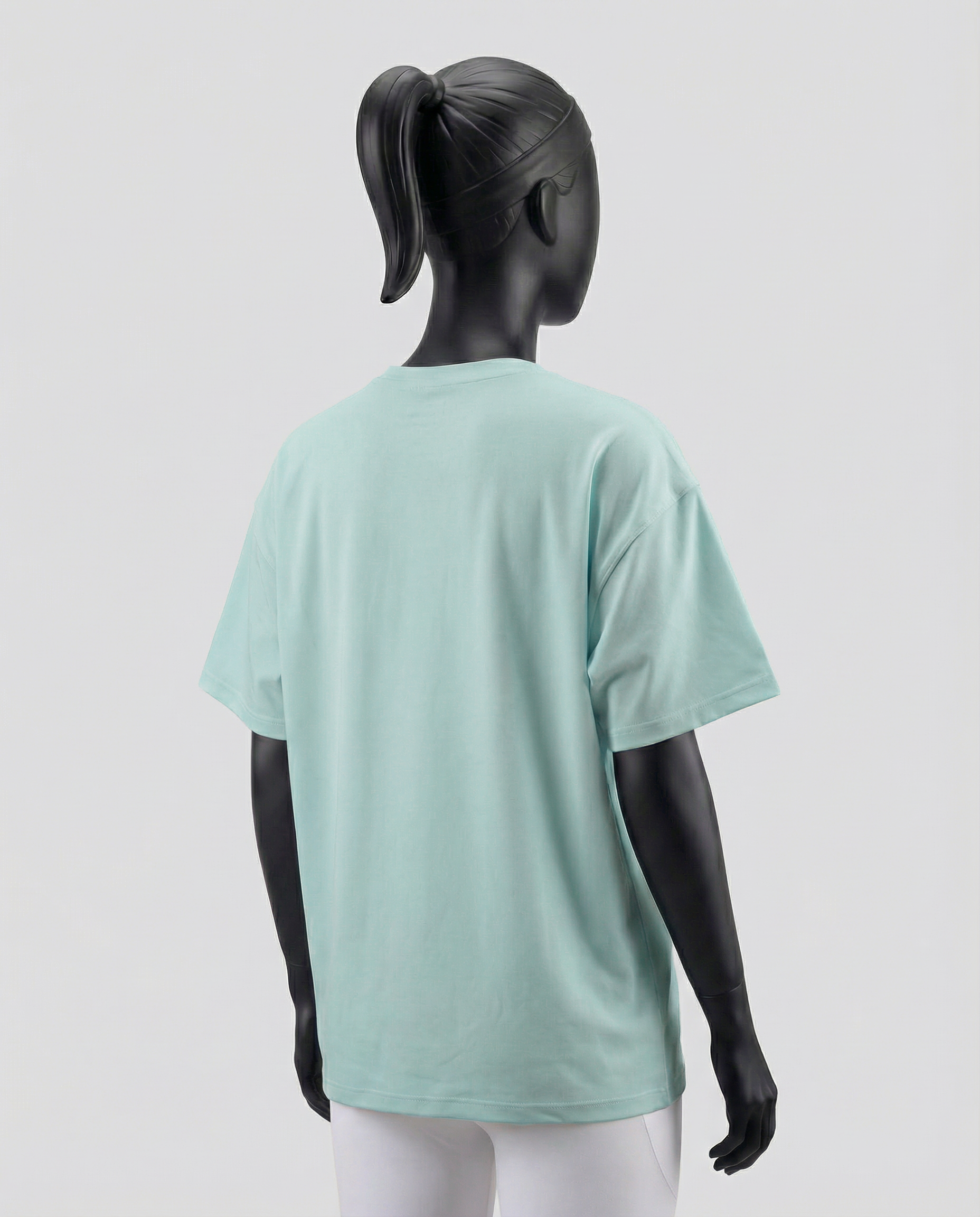 Mannequin wearing an oversized light green t-shirt on a plain background