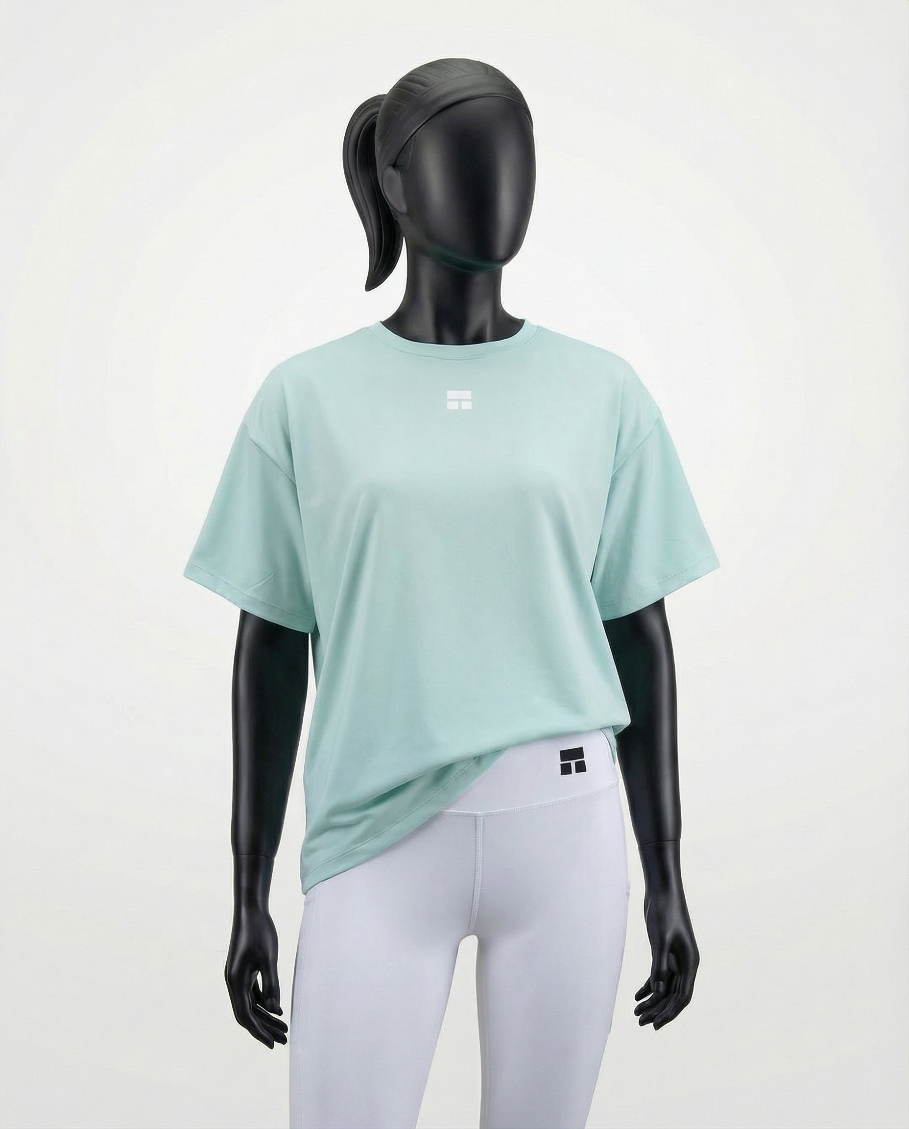 Mannequin wearing an oversized light green t-shirt on a plain background
