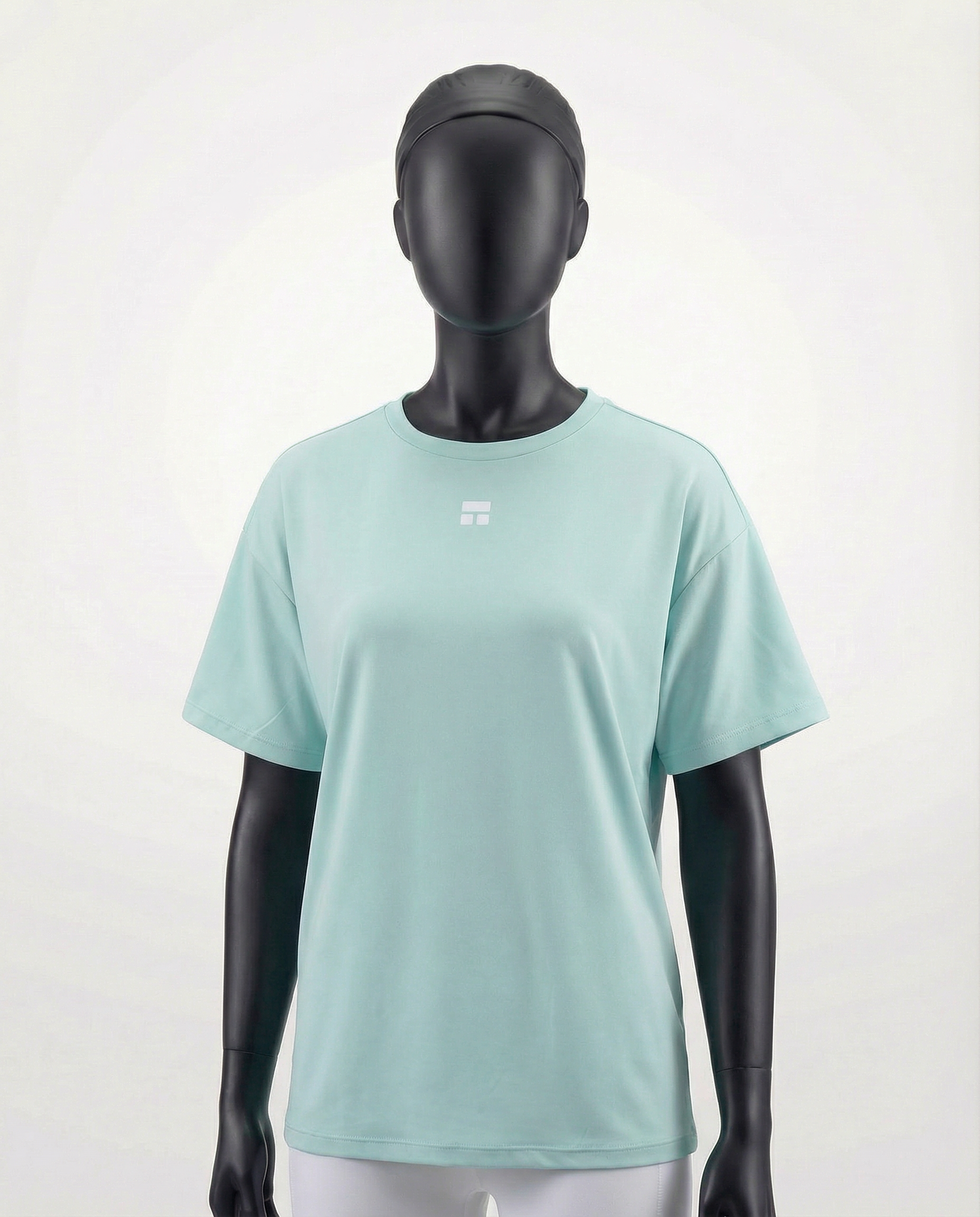 Mannequin wearing an oversized light green t-shirt on a plain background