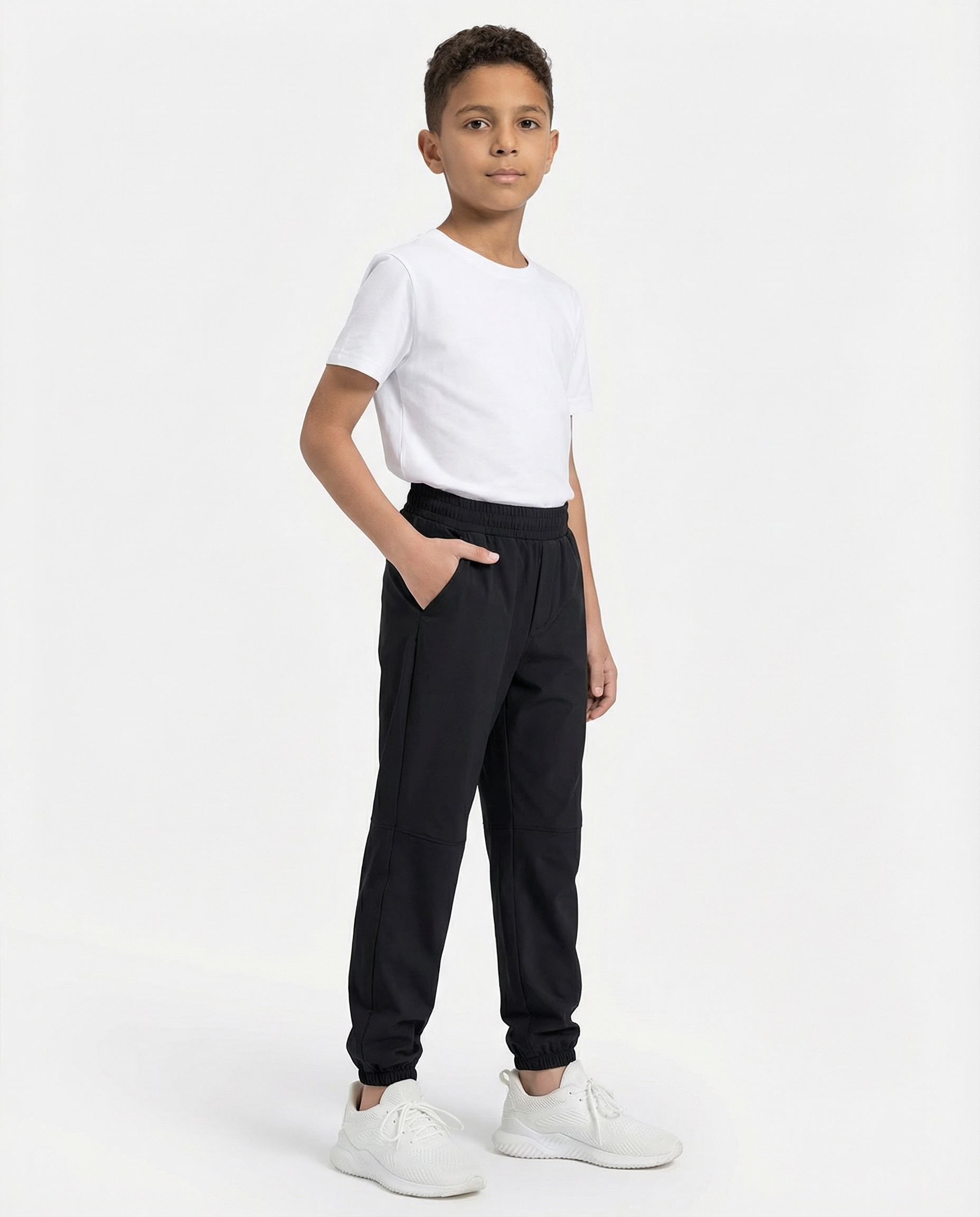 Person wearing black jogger pants and white sneakers on a white background
Courts Sport