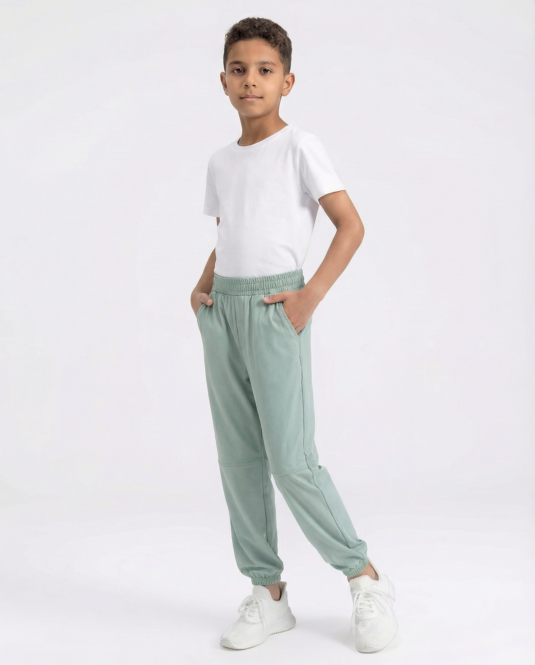 Child wearing a white t-shirt and light green pants on a white background
Courts Sport