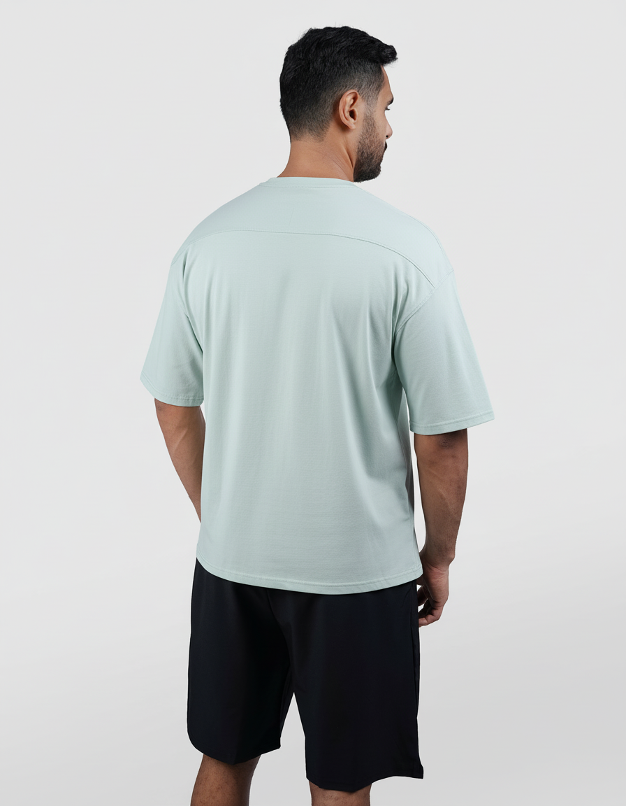 Man wearing a light blue t-shirt and black shorts on a white background