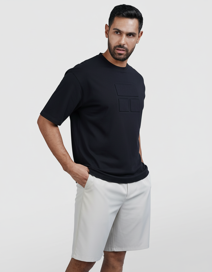 Man wearing a black t-shirt and white shorts on a light gray background