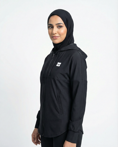 Person wearing a black hooded jacket with a logo on a white background
