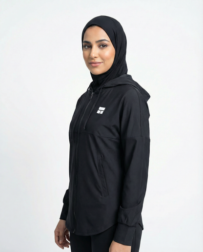 Person wearing a black hooded jacket with a logo on a white background
