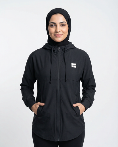 Person wearing a black hooded jacket with a logo on a white background
