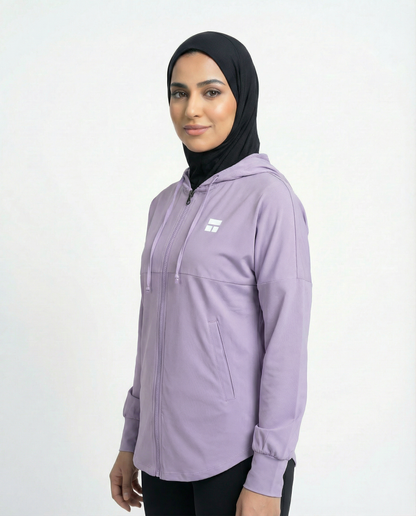Woman wearing a purple hoodie with a brand logo on a white background
