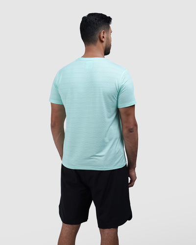 Man wearing a light blue t-shirt and black shorts on a white background
