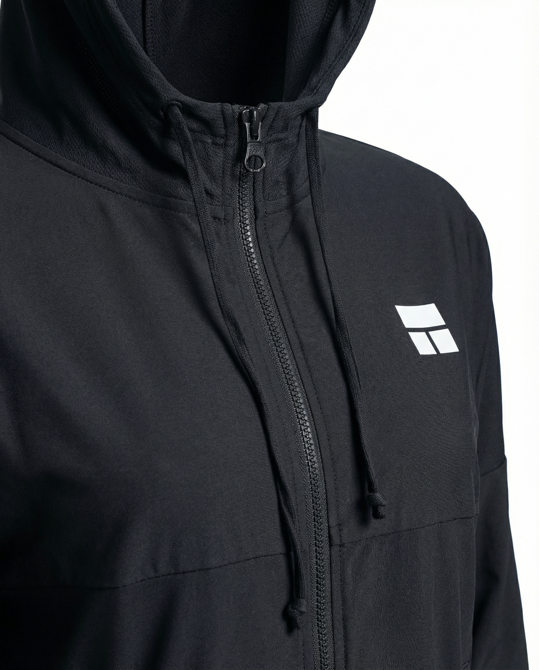 Person wearing a black hooded jacket with a logo on a white background
