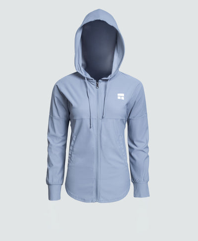 Woman wearing a light blue jacket with a logo on a white background
