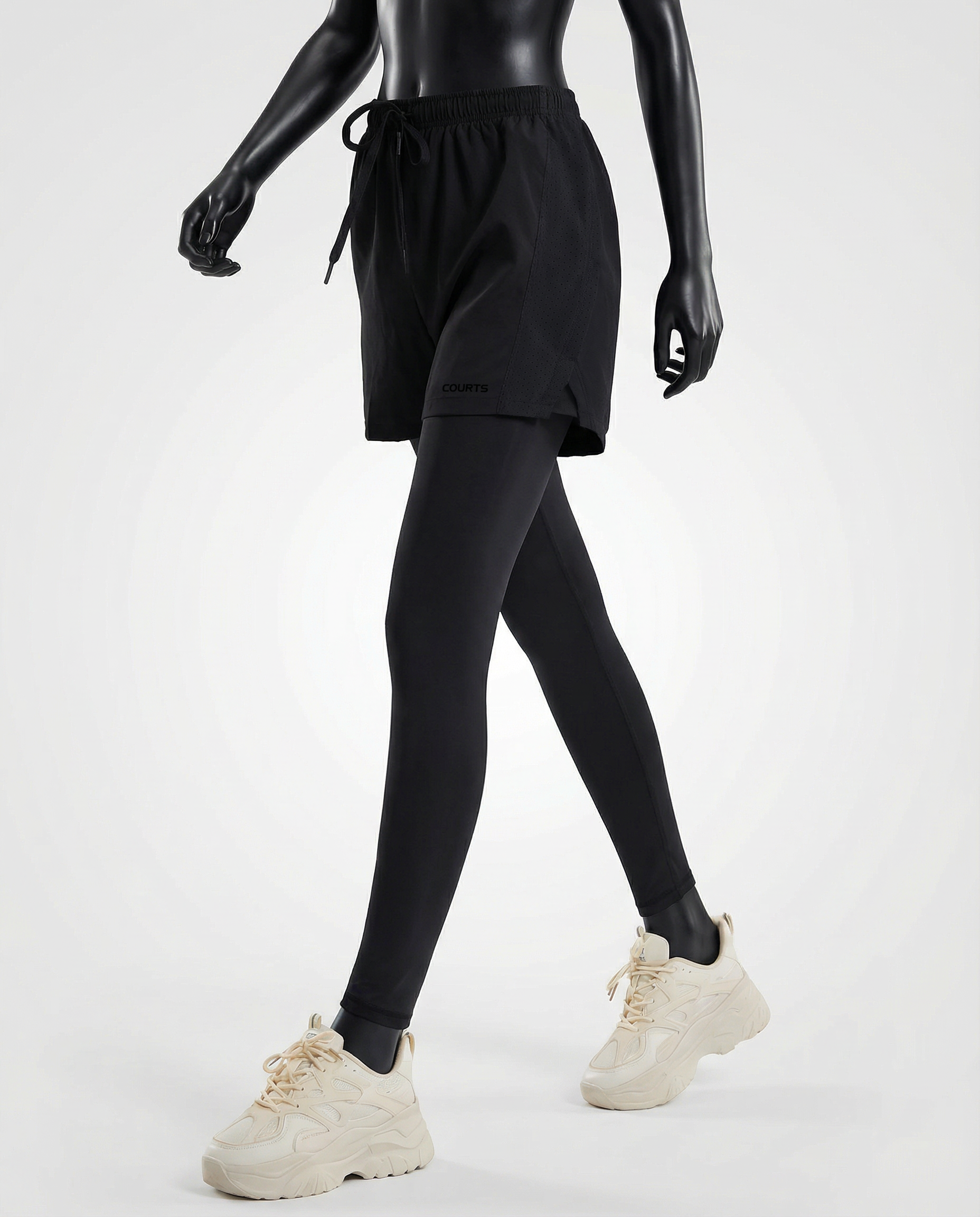 Mannequin wearing black athletic shorts and leggings with white sneakers on a light gray background
#color_black