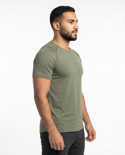 Man wearing an olive green athletic shirt on a white background
