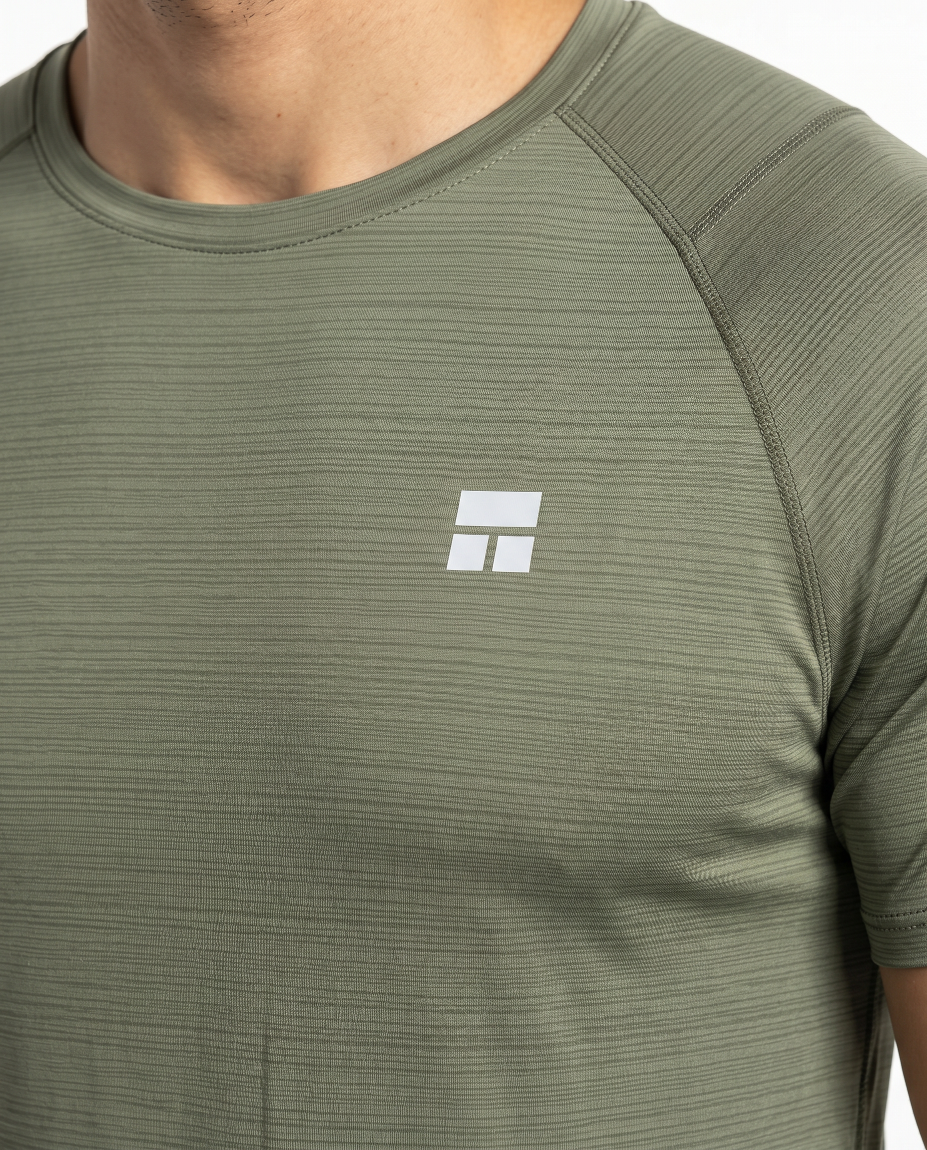 Man wearing an olive green athletic shirt on a white background
